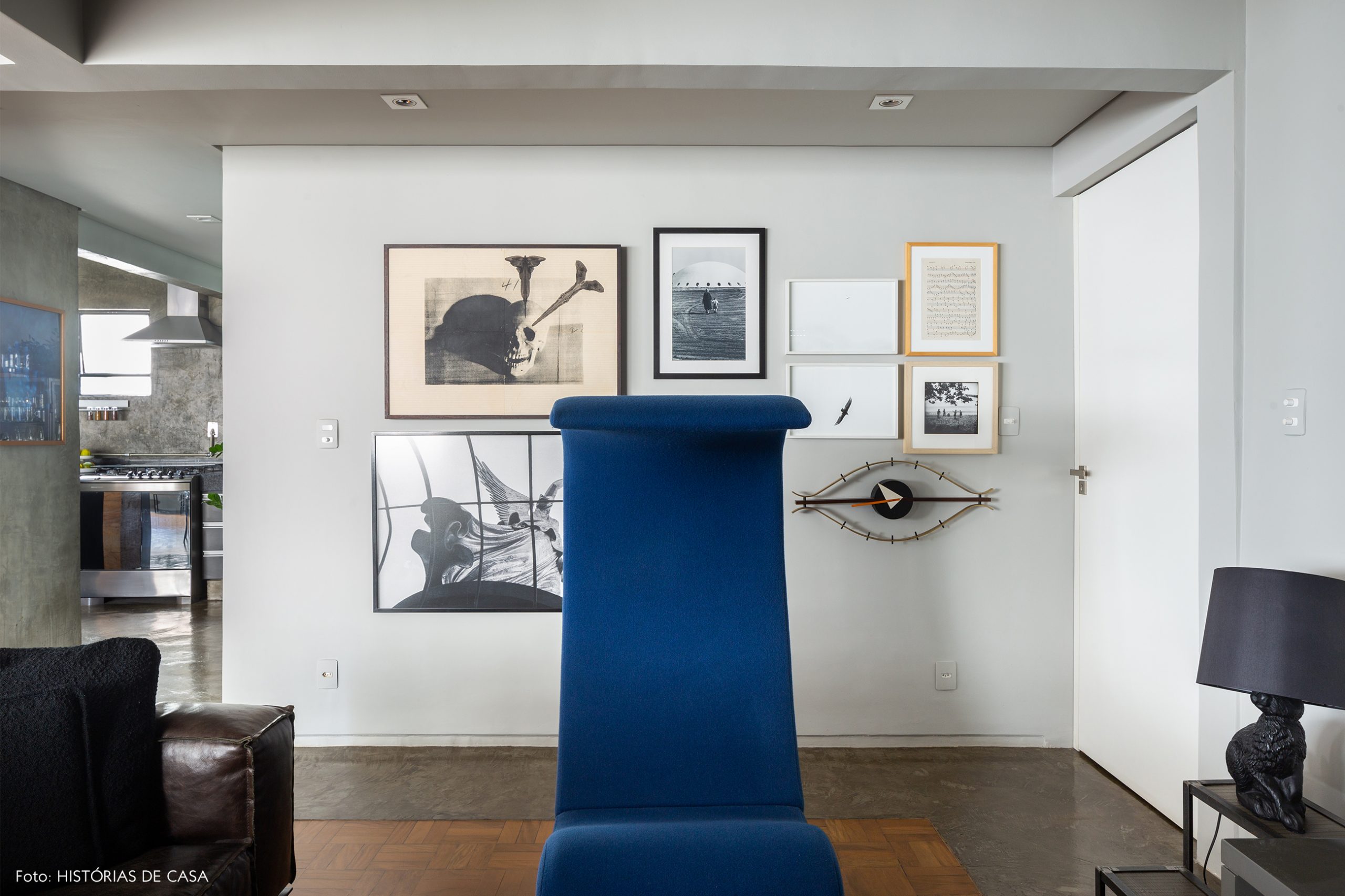 decoração sala com parede cinza quadros e poltrona azul
