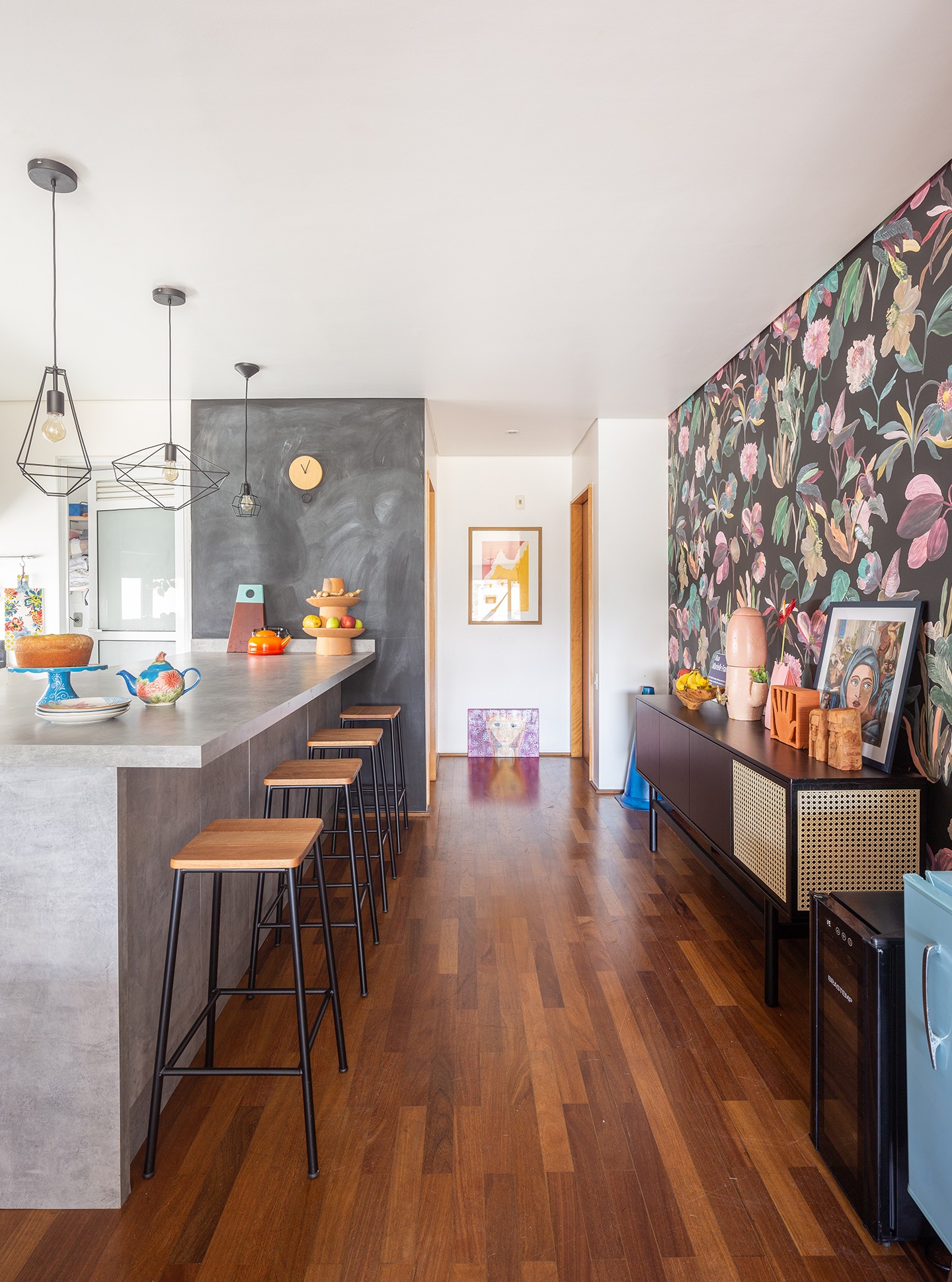 decoração cozinha com bancada de concreto e hall com papel de parede floral