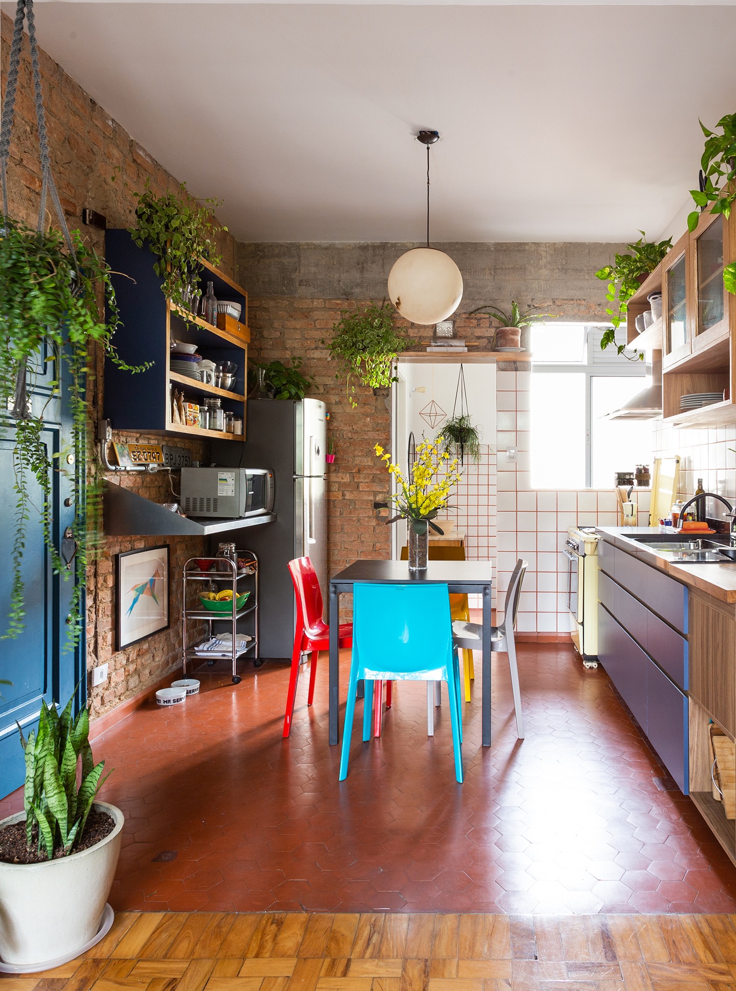 decoração cozinha com parede de tijolos cadeiras coloridas
