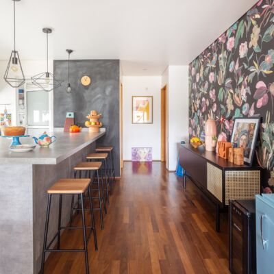 decoração cozinha com bancada de concreto e hall com papel de parede floral