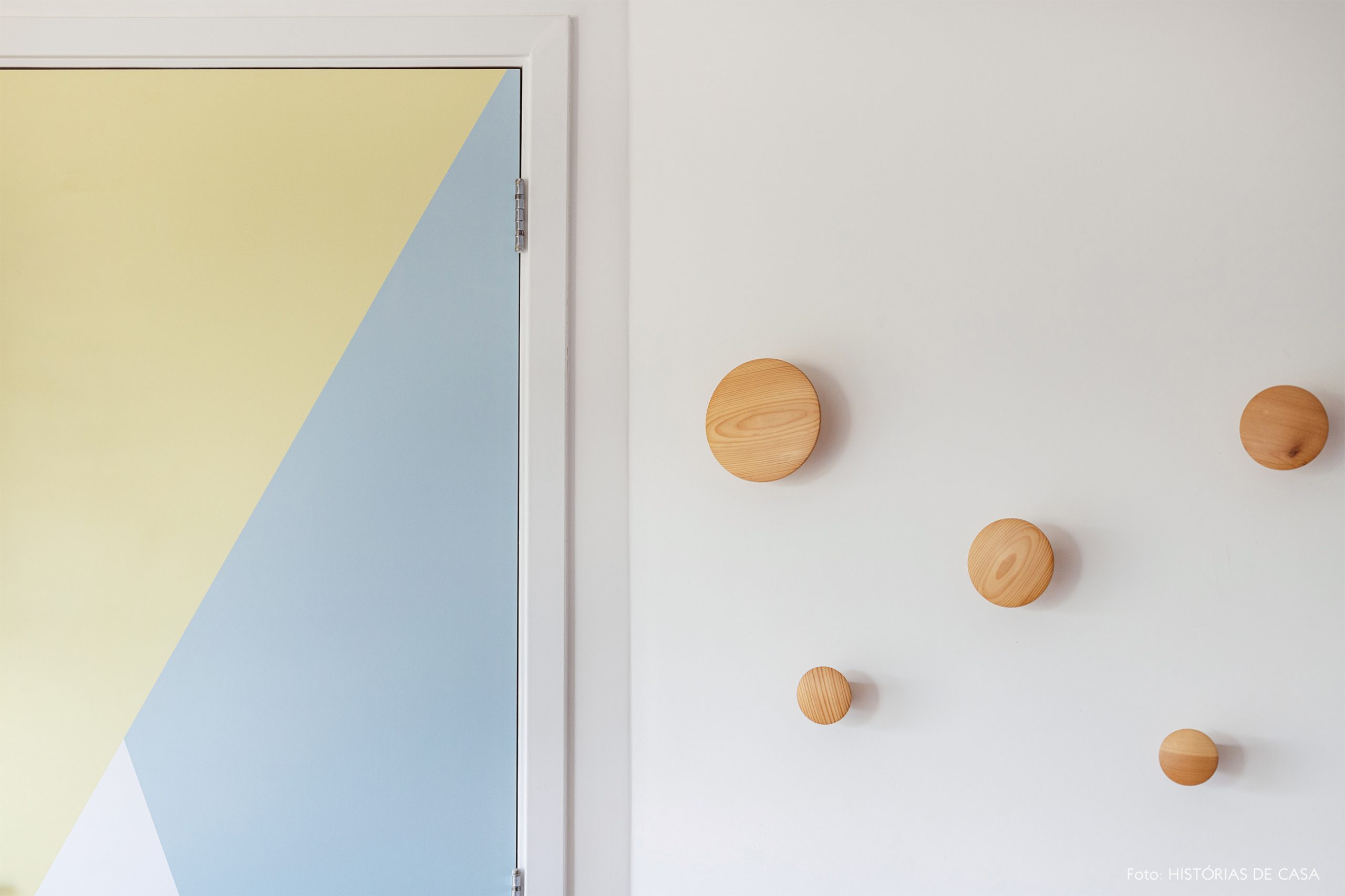 decoração porta com adesivo geométrico e ganchos de madeira