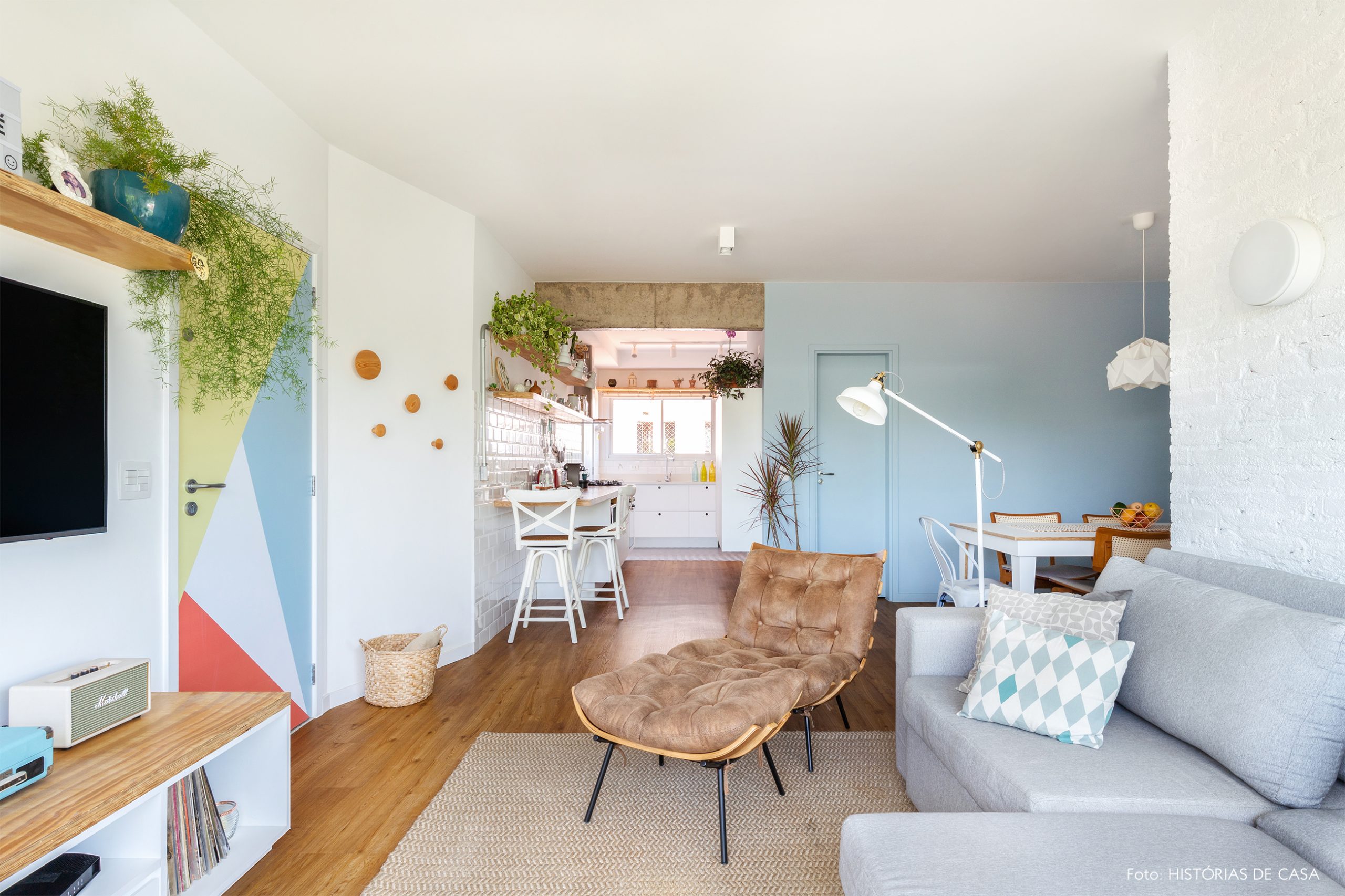 decoração sala com poltrona, porta com adesivo e cesto