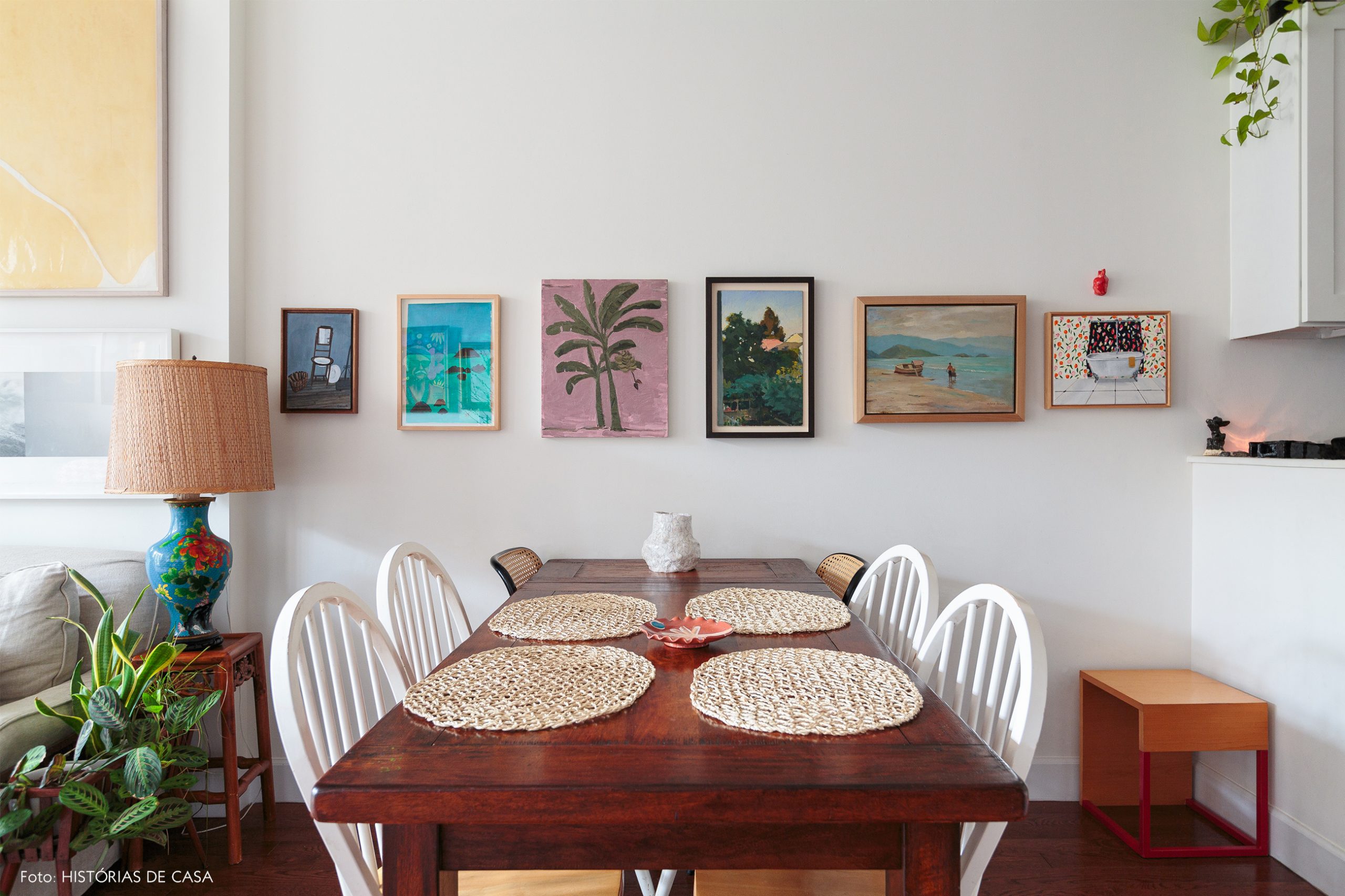 ap decoração sala jantar com mesa de madeira e muitos quadros