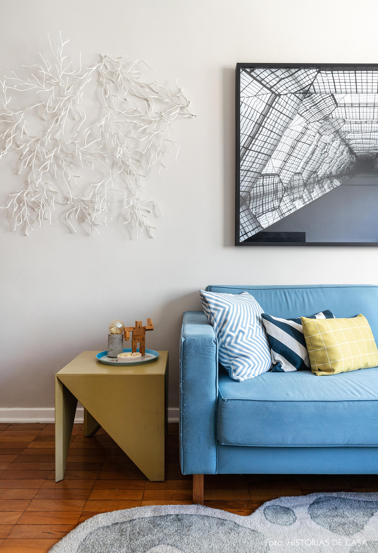 decoração apartamento alugado quinto andar sala colorida com sofá azul e mesa lateral geométrica de madeira