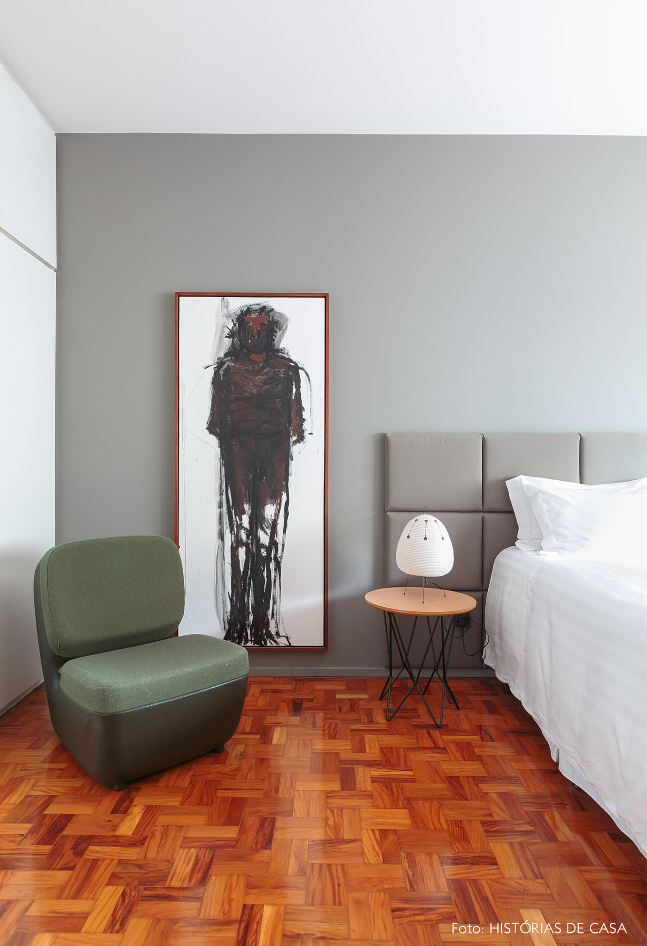 decoração quarto com parede cinza quadro de pintura e cadeira verde