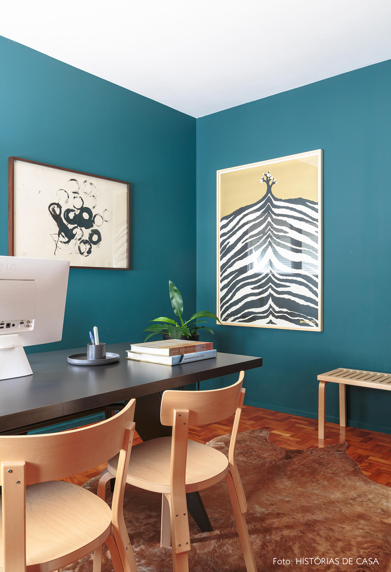decoração home office de parede azul com cadeiras de madeira e obras de arte