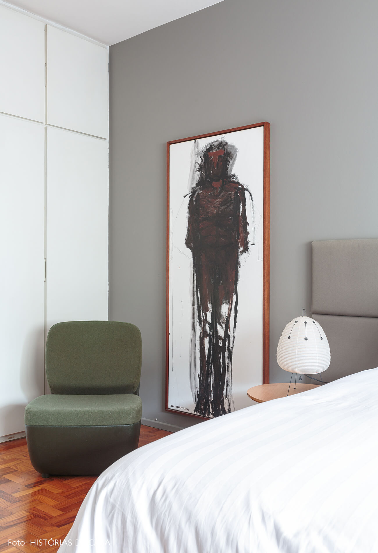 decoração quarto com parede cinza quadro de pintura e cadeira verde