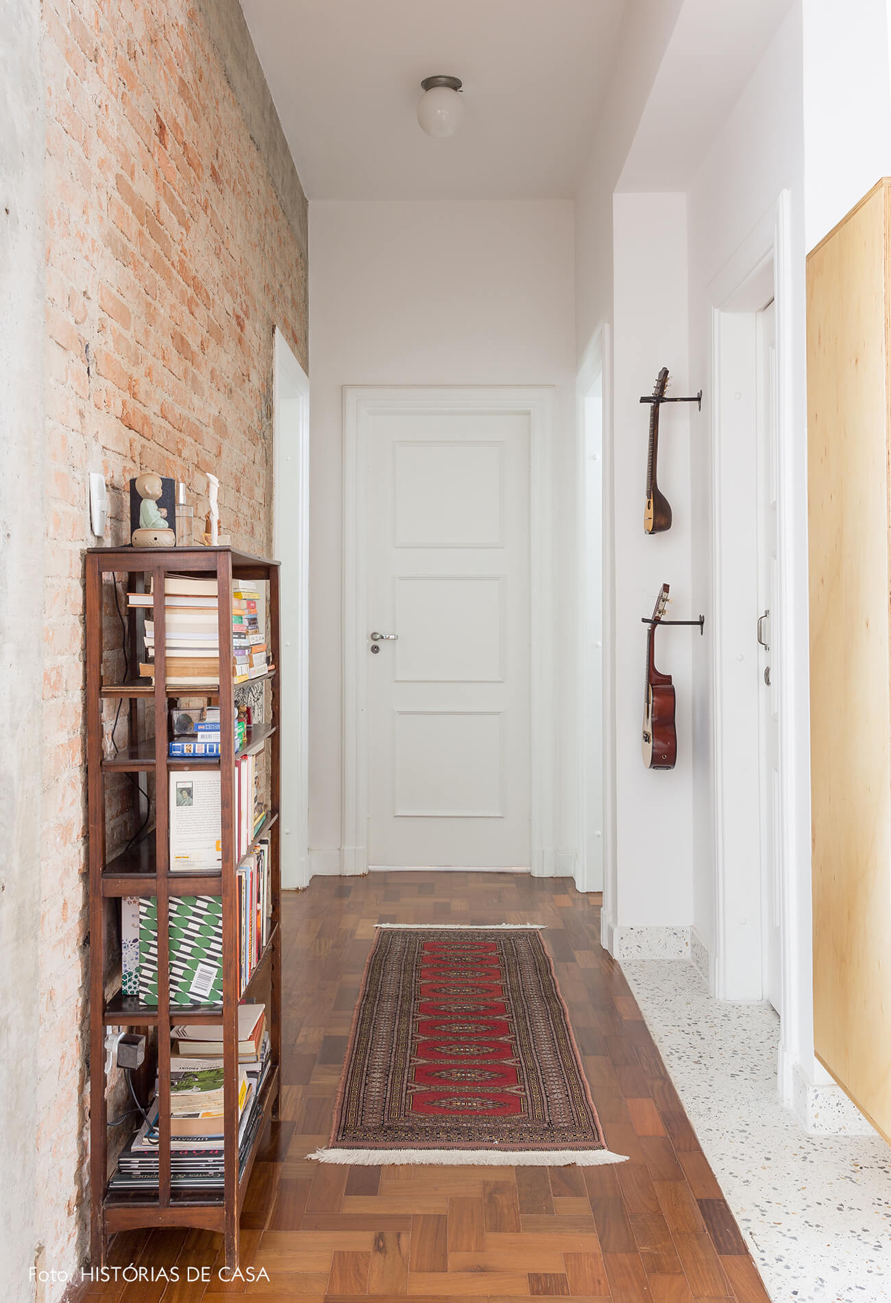 decoração corredor com parede de tijolinhos e chão de taco