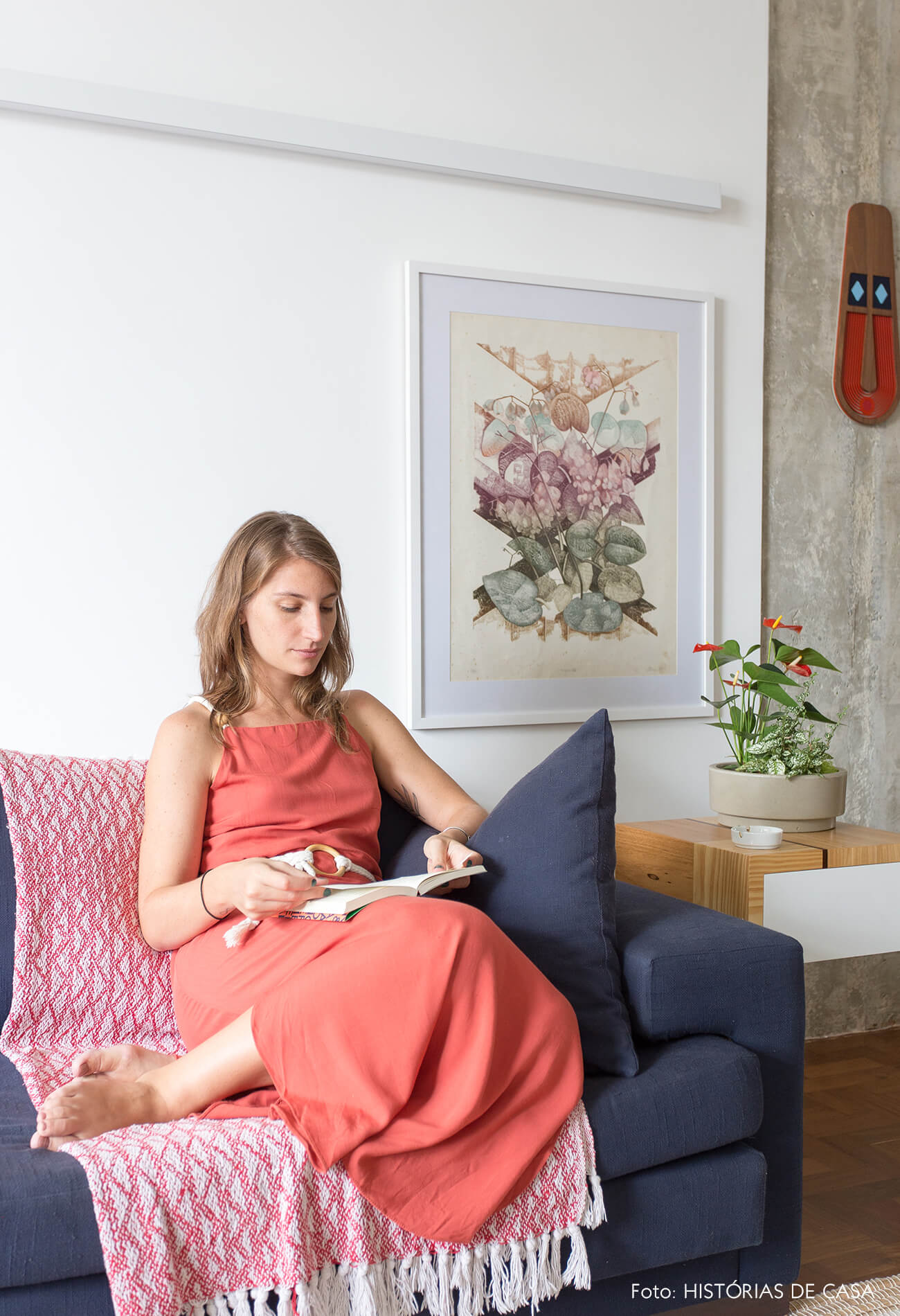 decoração retrato em sala com sofá azul e mesa de madeira