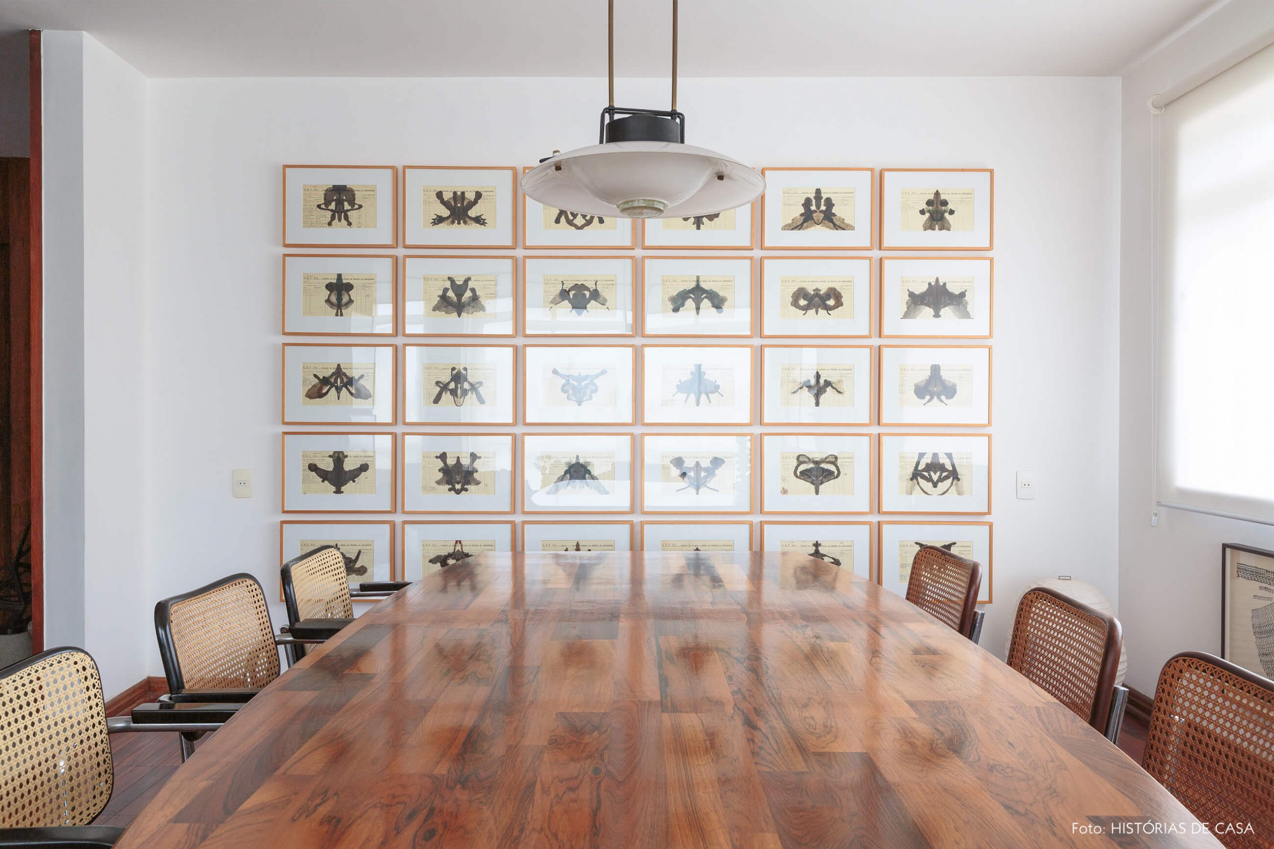 decoração sala jantar com cadeira palhinha e obras de arte