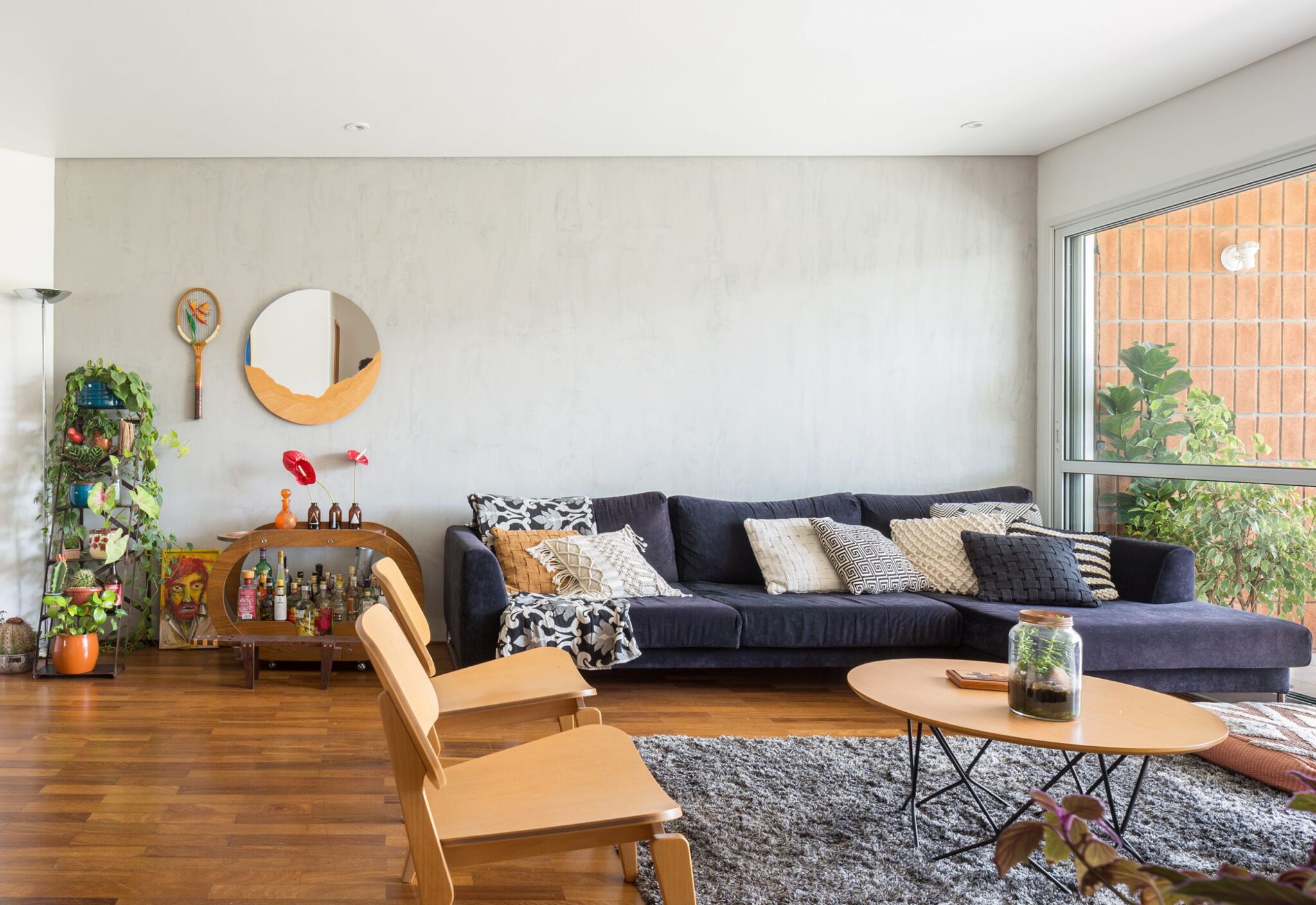 decoração sala com parede cinza cadeira eames e bar de madeira