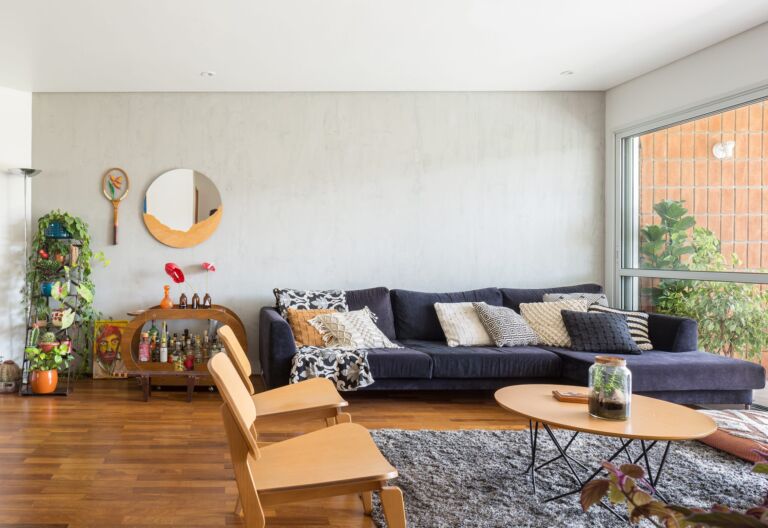 decoração sala com parede cinza cadeira eames e bar de madeira