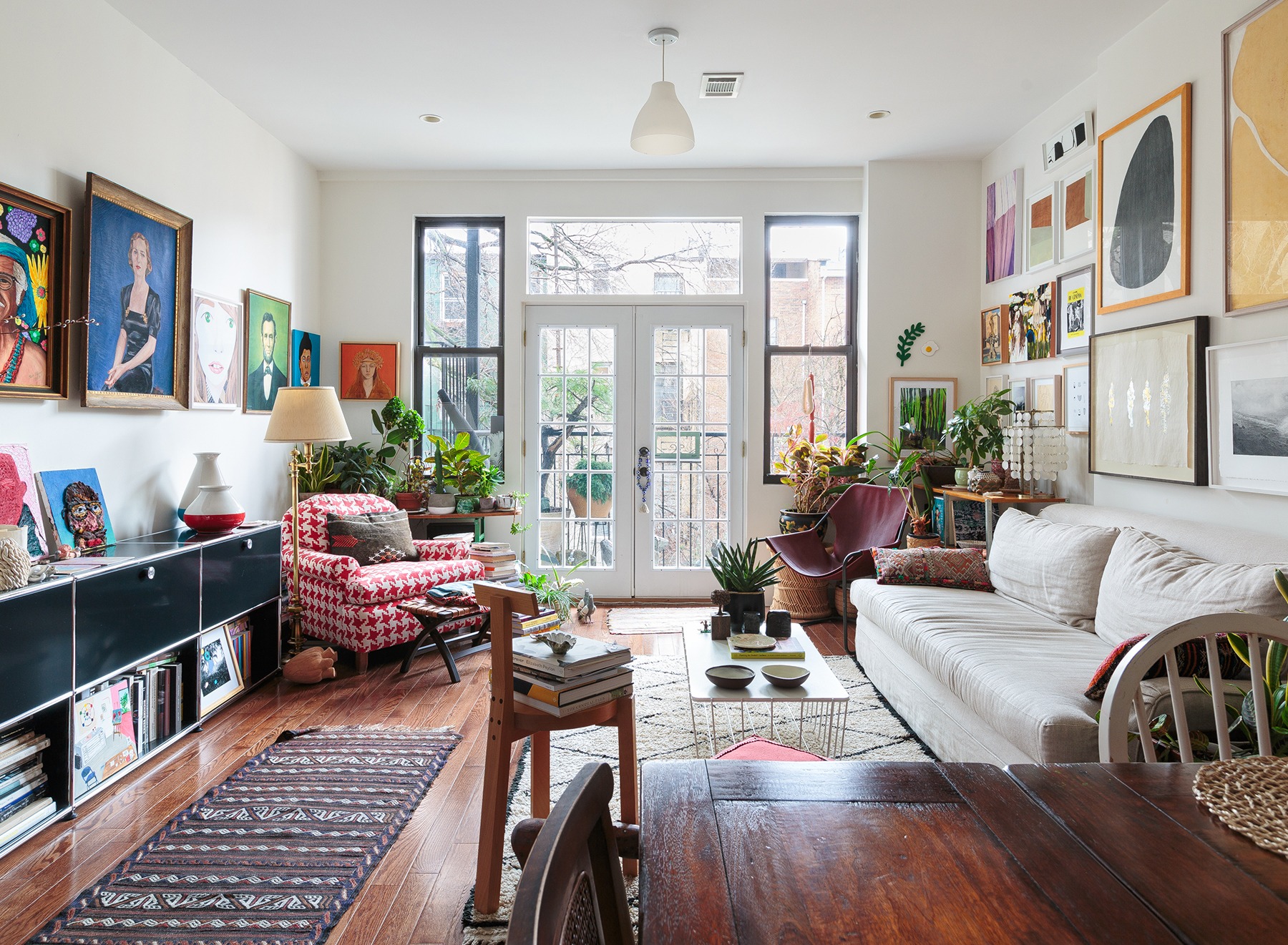 ap decoração sala colorida com muitos quadros e poltrona vermelha