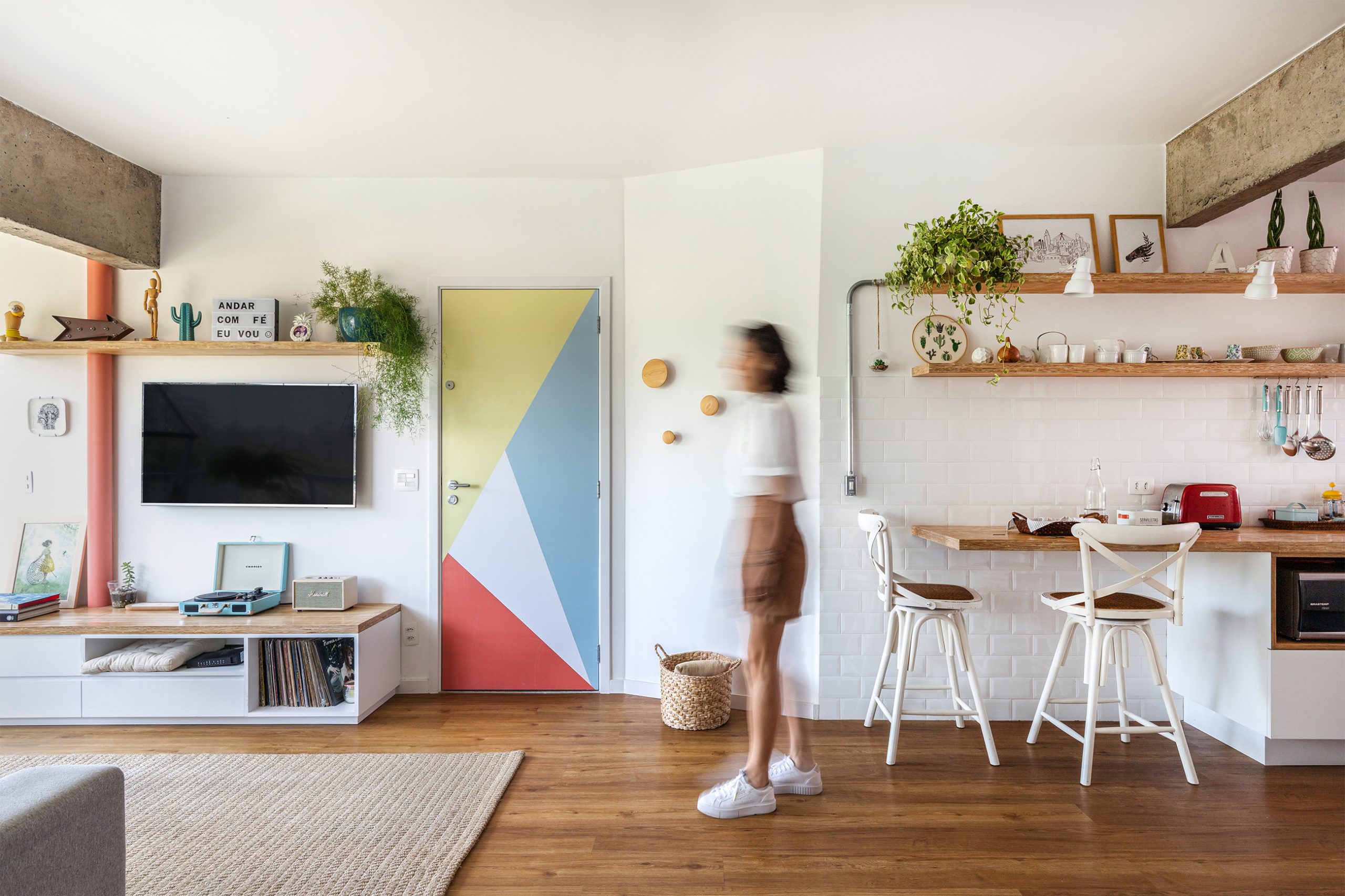decoração sala com adesivo na porta, cesto e ganchos de madeira