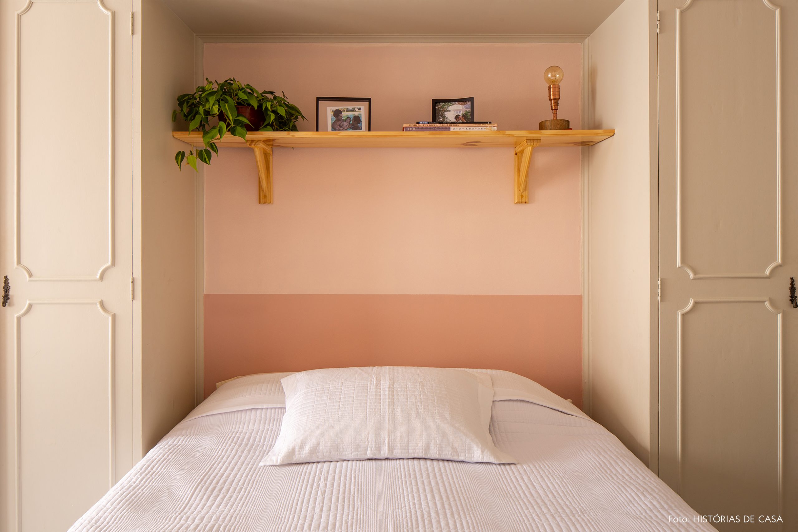 decoração quarto com parede rosa e prateleira de madeira