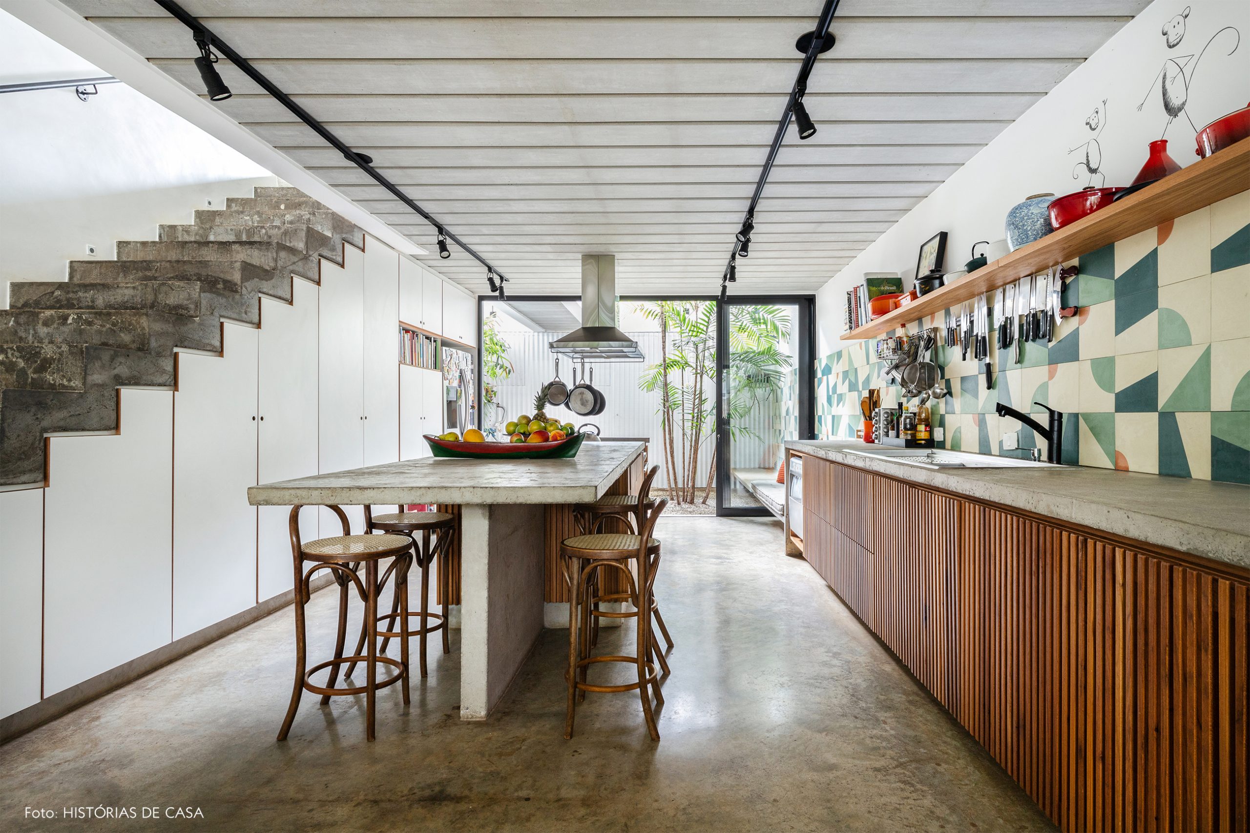 decoração casa cozinha com azulejos coloridos na parede, bancada de concreto e cadeira thonet