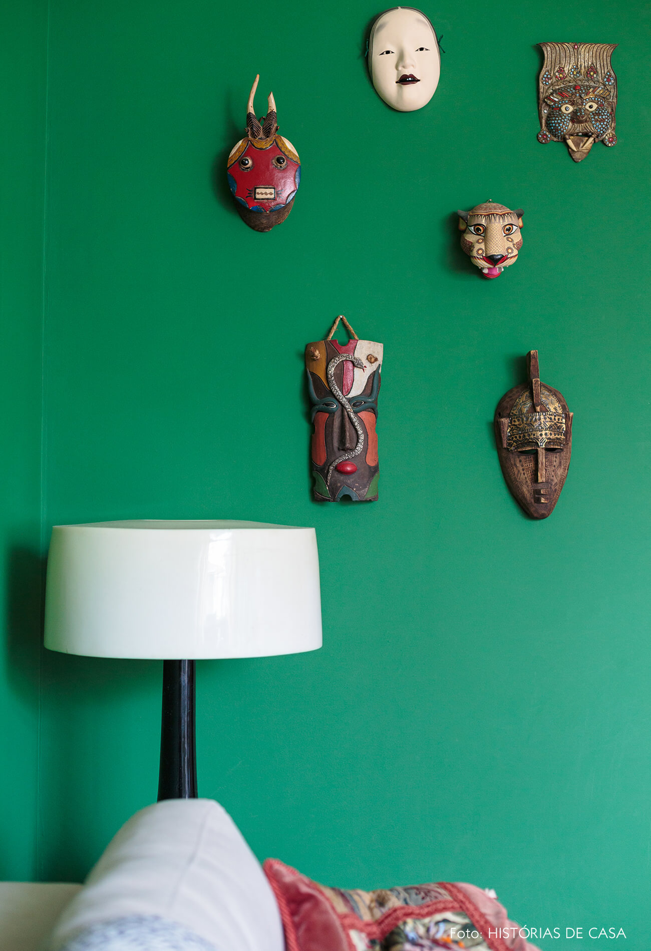 decoração sala com parede verde e mascaras na parede