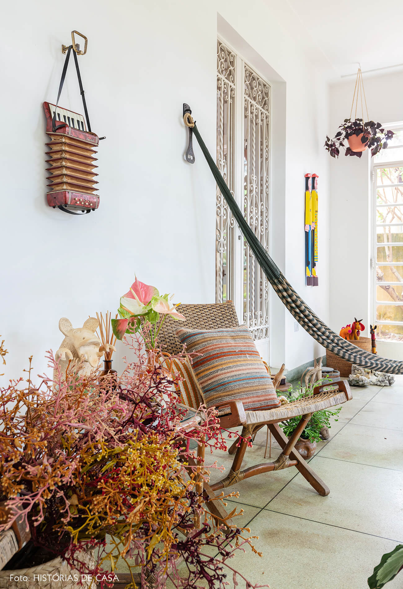 decoração varanda com plantas e cadeira de madeira
