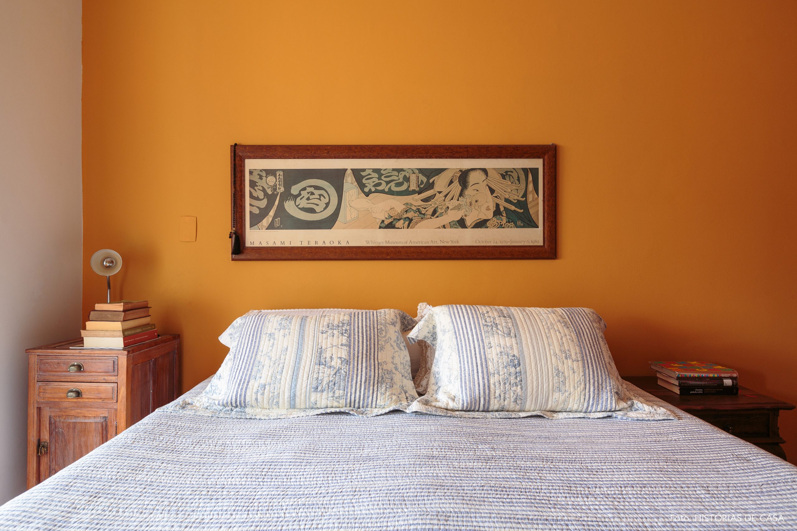 decoração quarto com parede amarela com mesa lateral de madeira