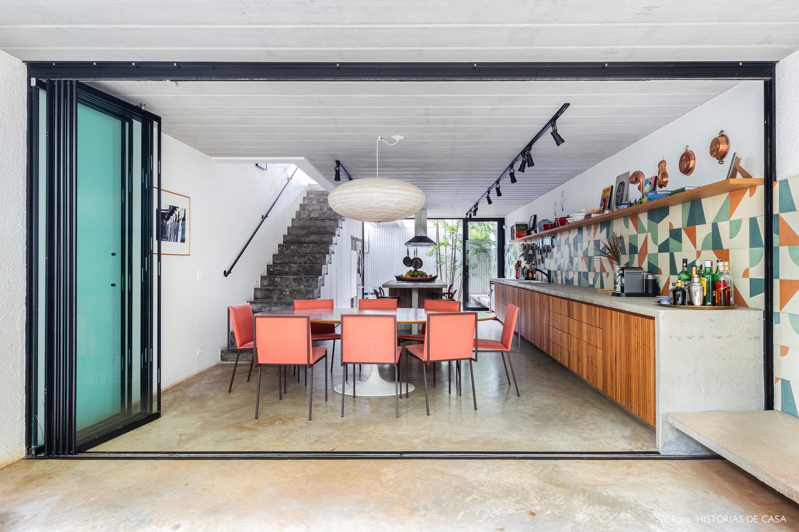 decoração casa cozinha com painel colorido, cadeiras salmao e bancada de concreto