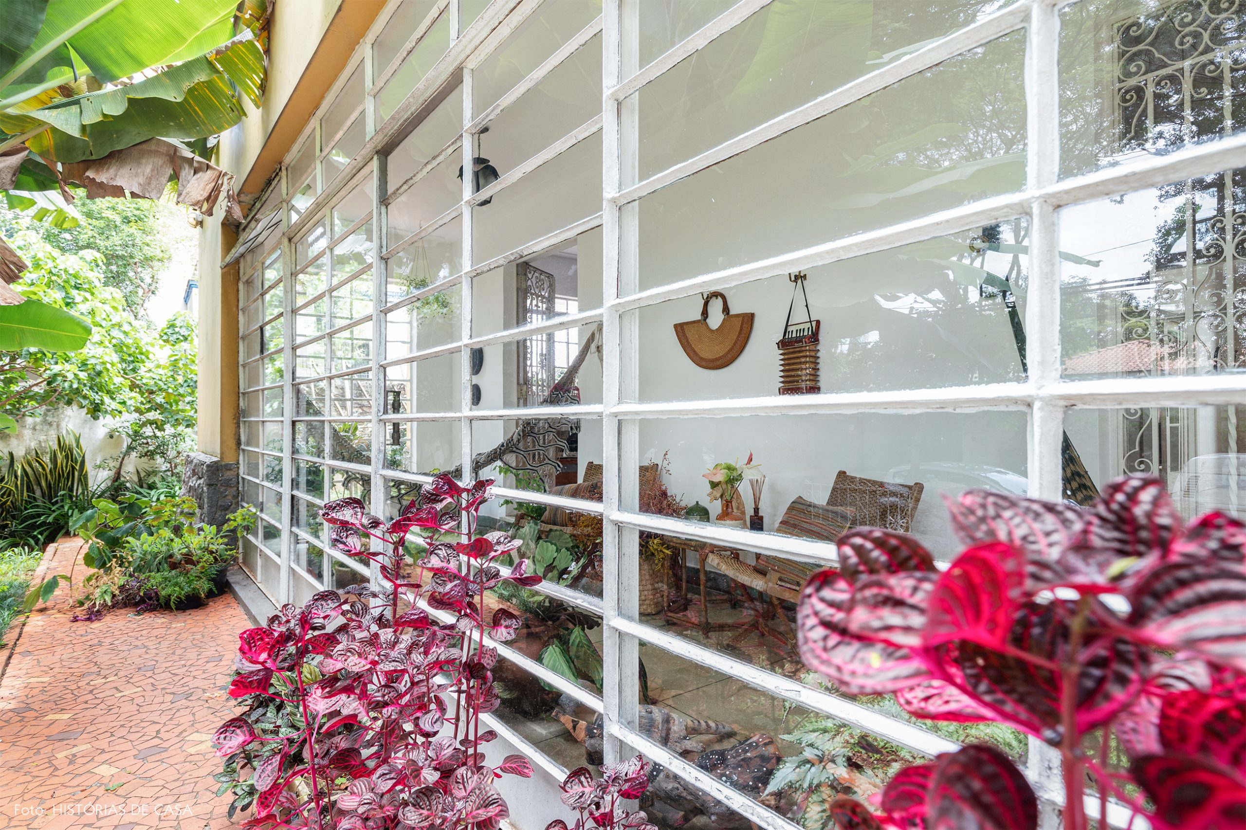 decoração varanda com porta de vidro, redes e muitas plantas