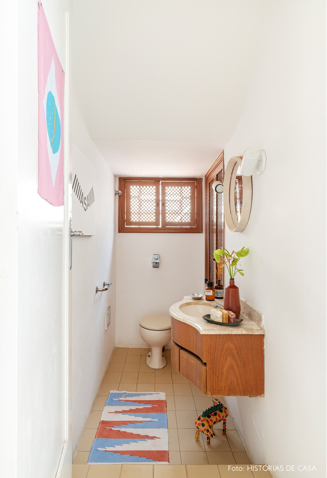 decoração banheiro com tapete estampado e espelho redondo