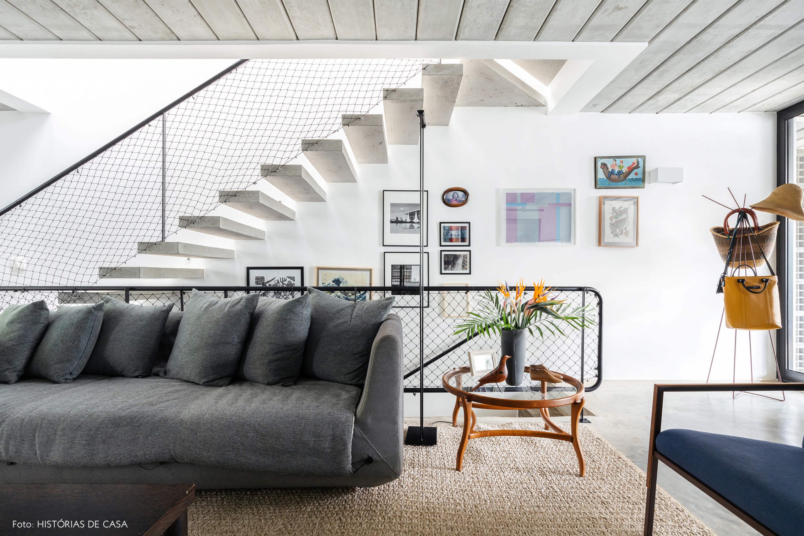 decoração casa sala com sofá cinza e escada de concreto