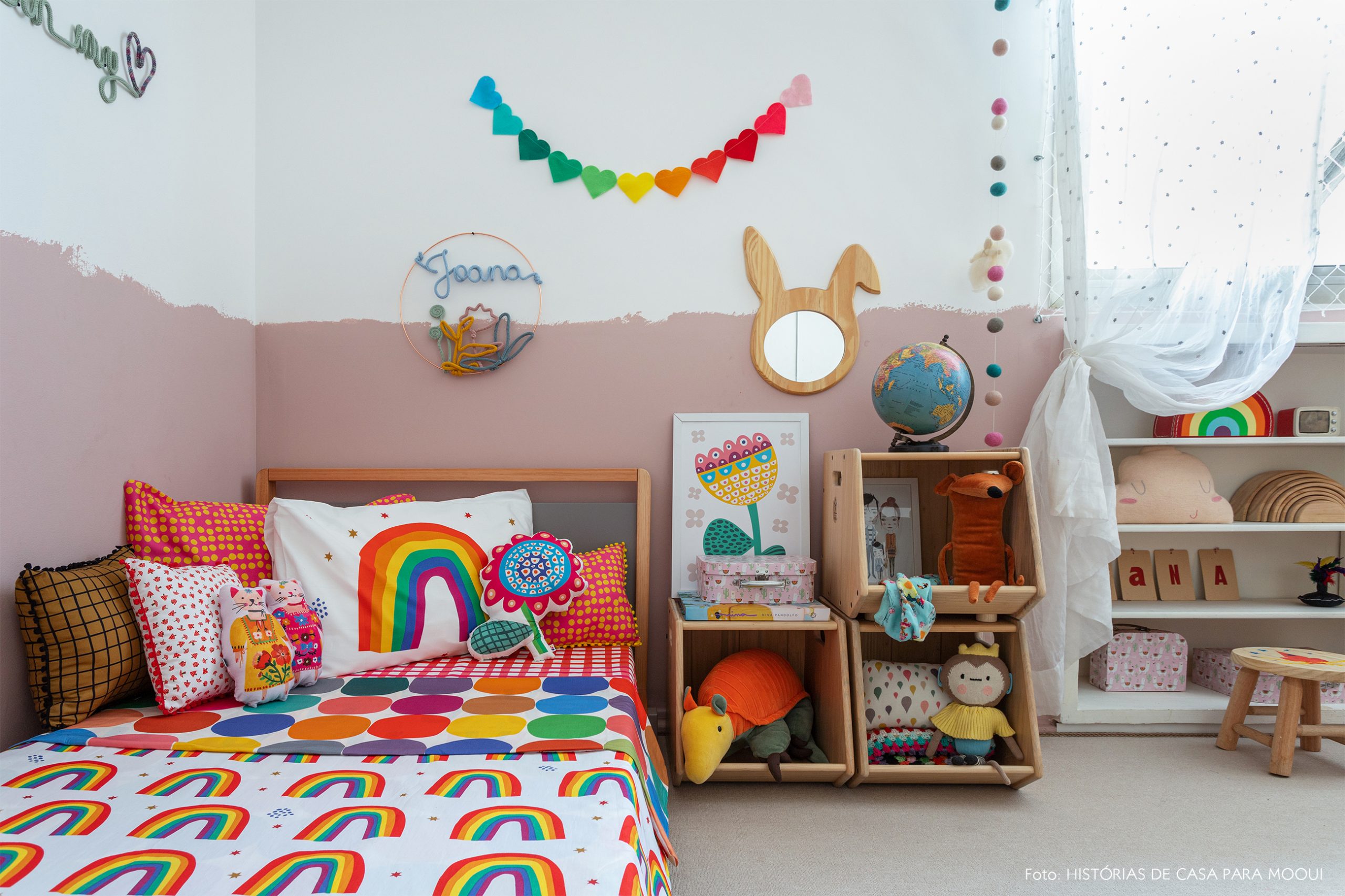 Quarto de criança com roupa de cama de arco-íris