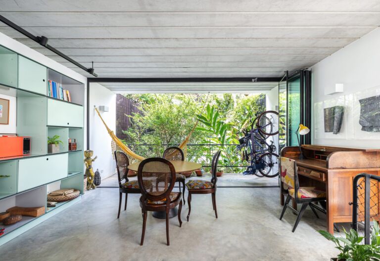 decoração casa sala com estante de metal verde, rede, e mesa de madeira