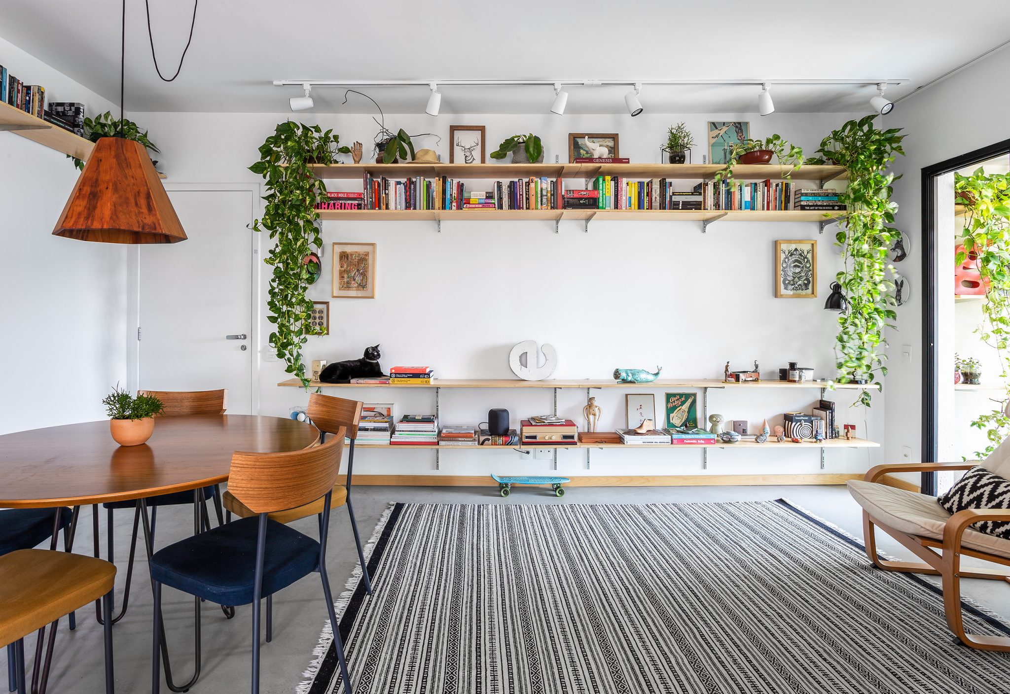 decoração sala com prateleiras e mesa de madeira com plantas