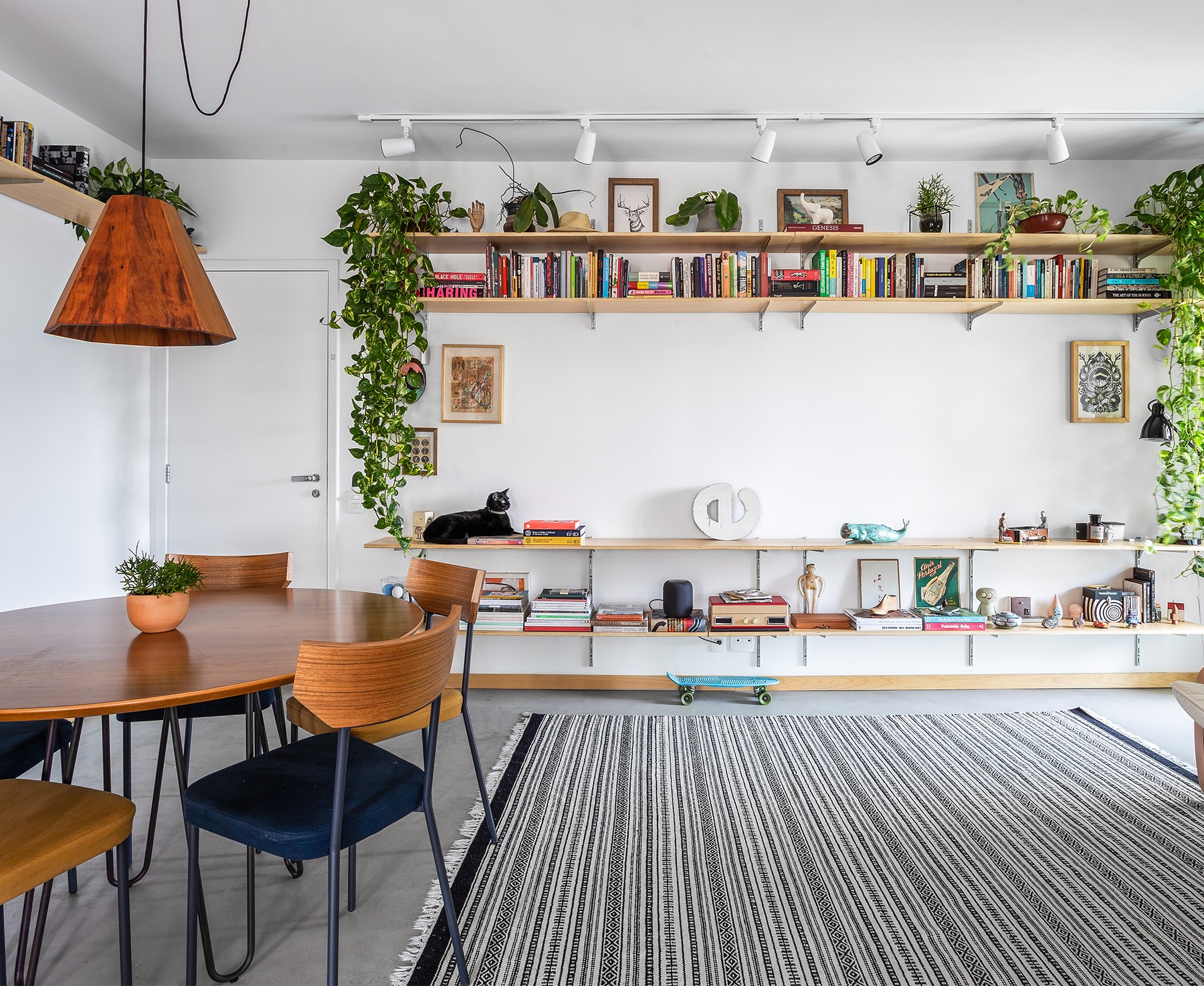 decoração sala com prateleiras e mesa de madeira com plantas