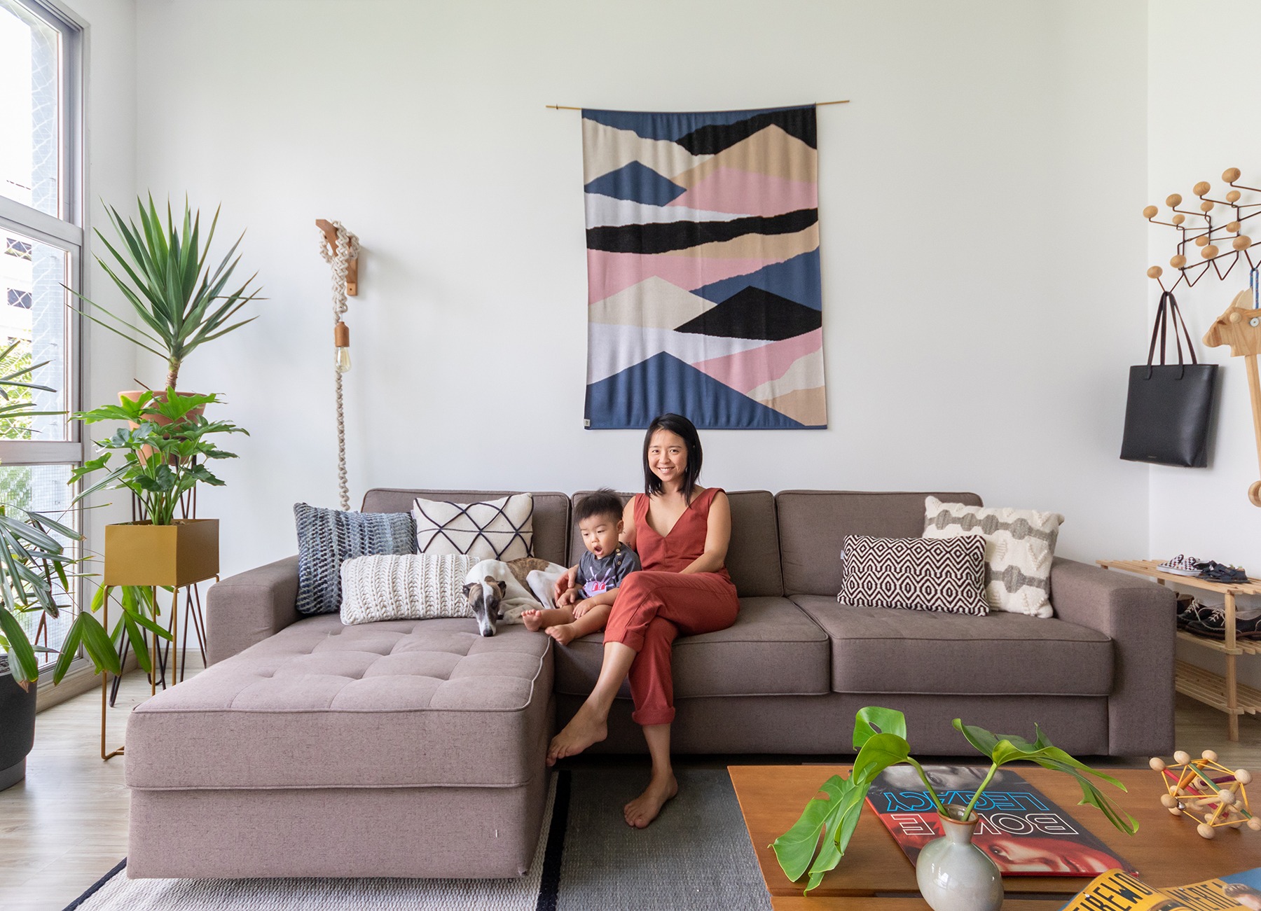 decoração sala com sofá cinza, cabideiro eames e manta na parede