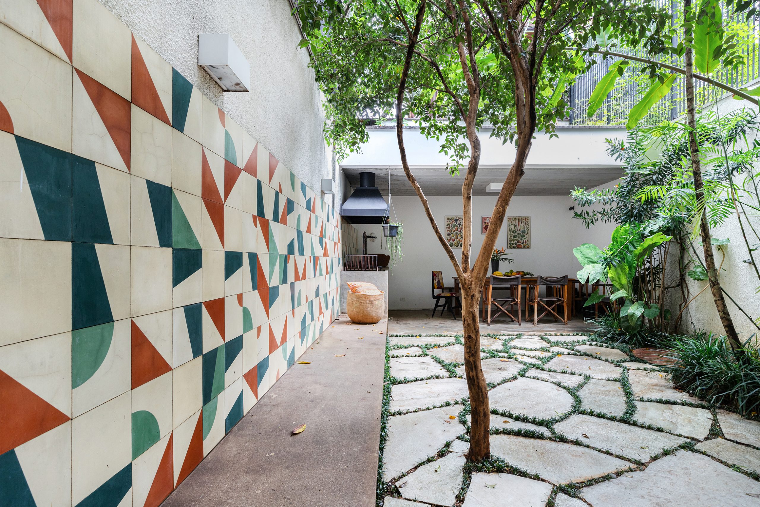 decoração casa jardim com azulejos coloridos, banco de concreto e churrasqueira