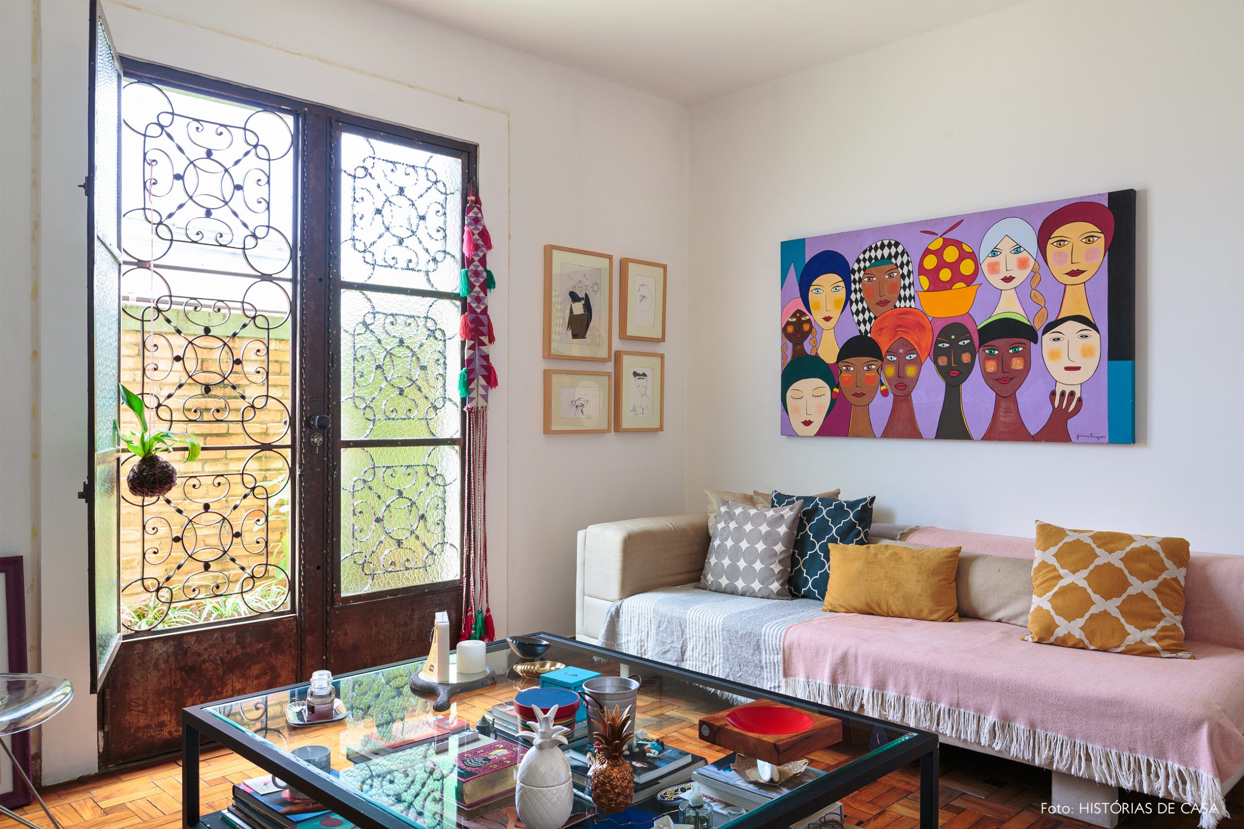 decoração sala colorida com mesa de centro de vidro e quadros