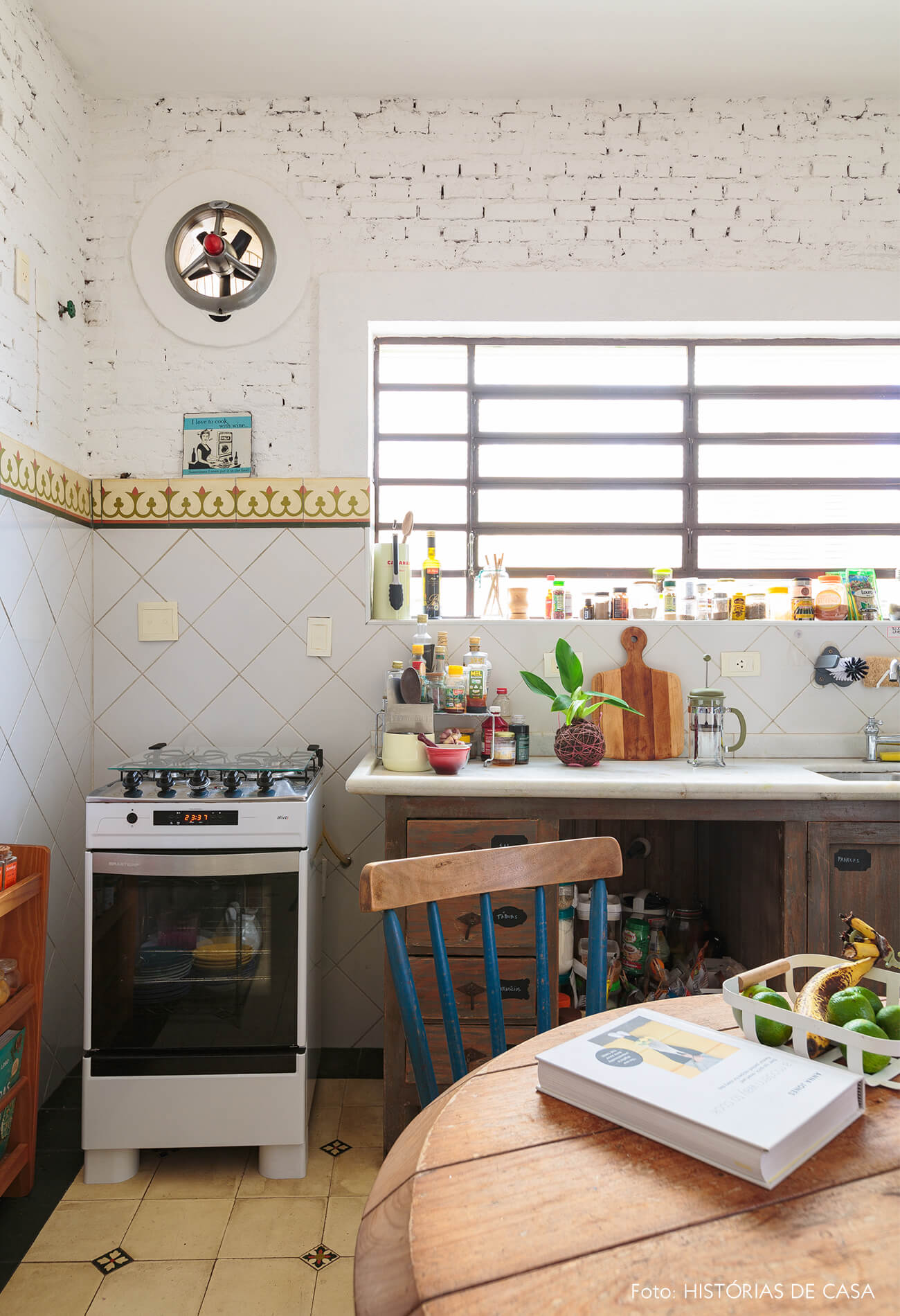 decoração cozinha com parede de tijolos brancos e azulejos coloridos mesa de madeira