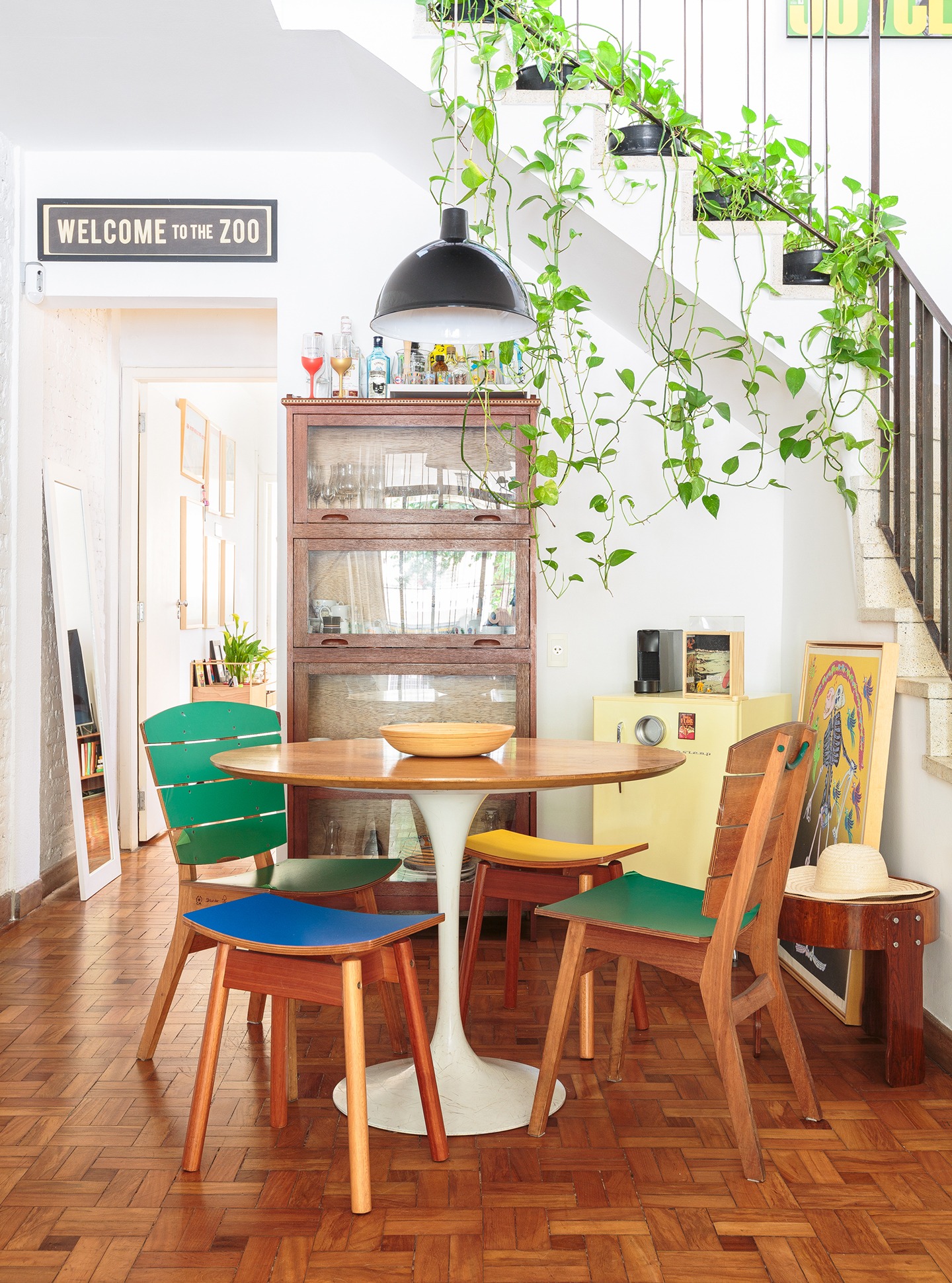 decoração sala jantar com mesa de madeira e cadeiras coloridas