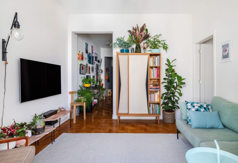 decoração sala com sofa azul muitas plantas banco girafa lina