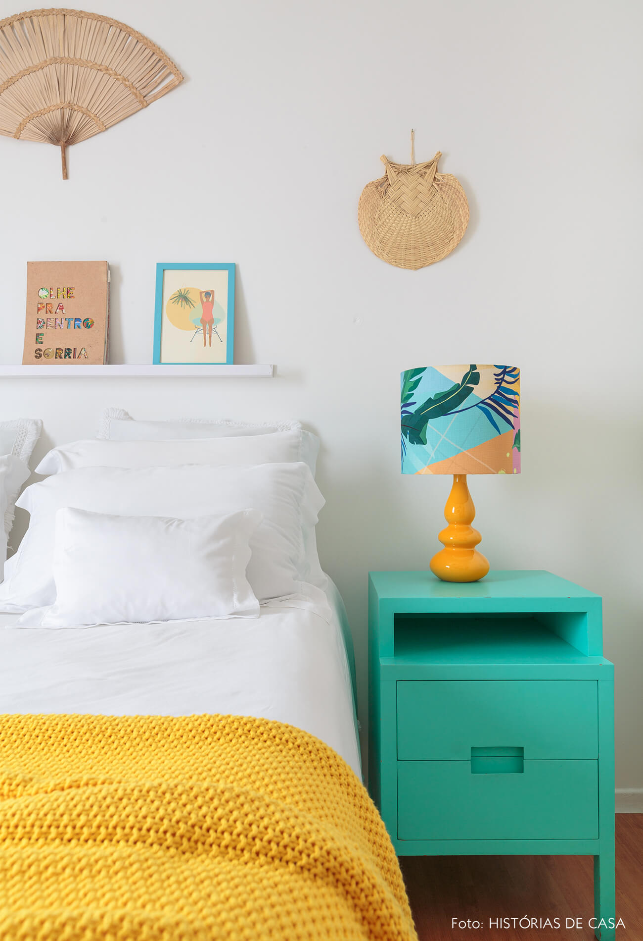 decoração praiana quarto com mesa lateral azul e leques na parede