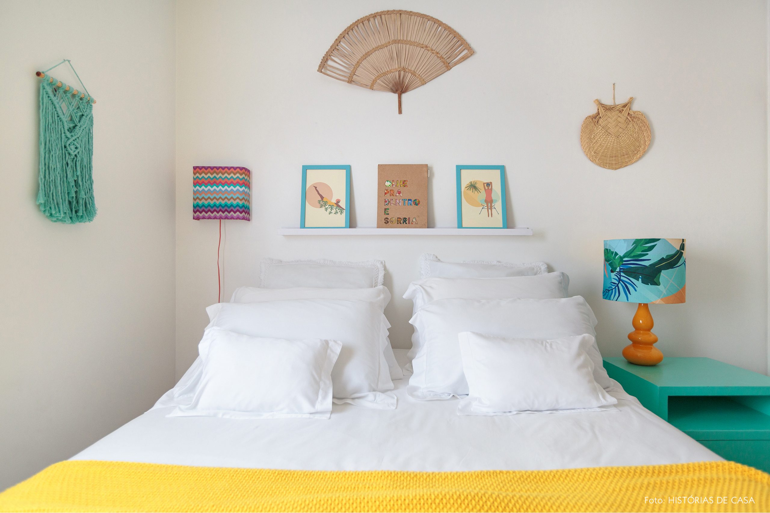 decoração praiana quarto com leques e tapeçaria na parede e luminária colorida