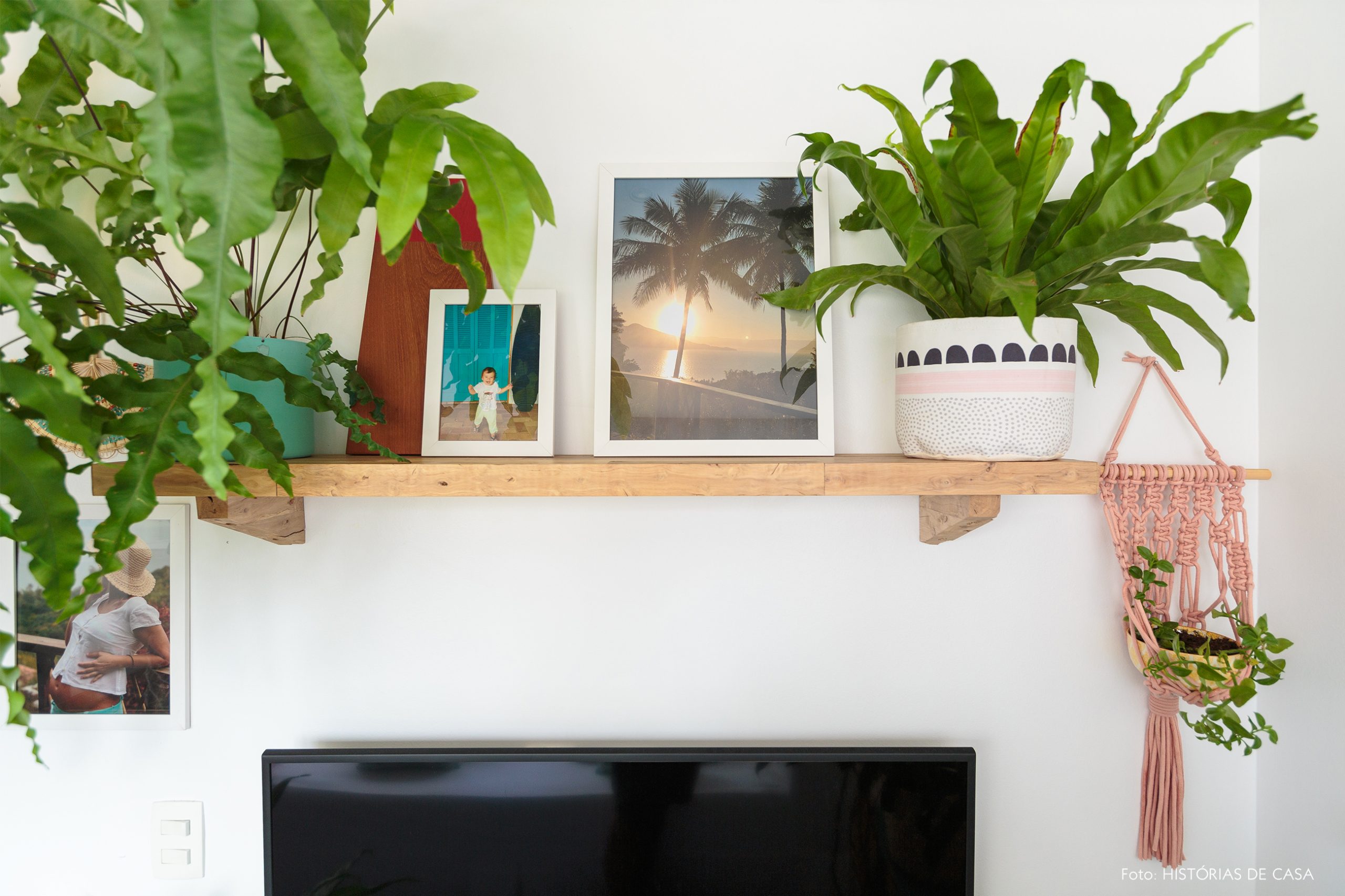decoração praiana prateleira de madeira na sala com plantas e macrame