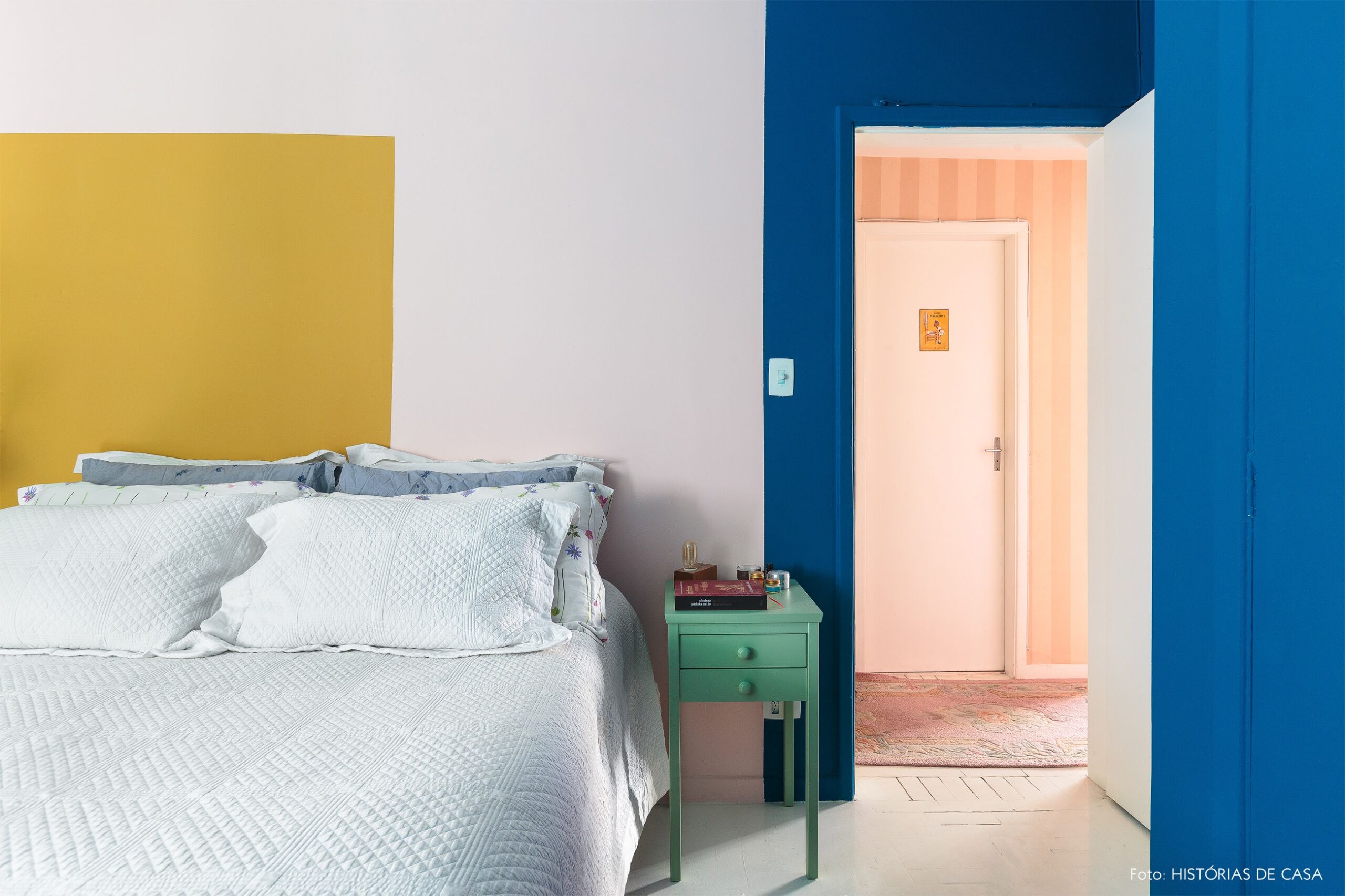 decoração colorida quarto com parede amarela e porta azul