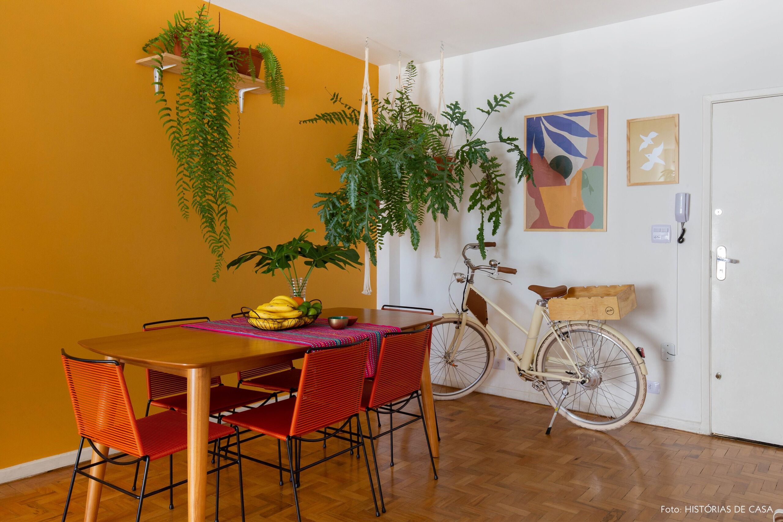 decoração obrah sala jantar parede mostarda quadros coloridos plantas