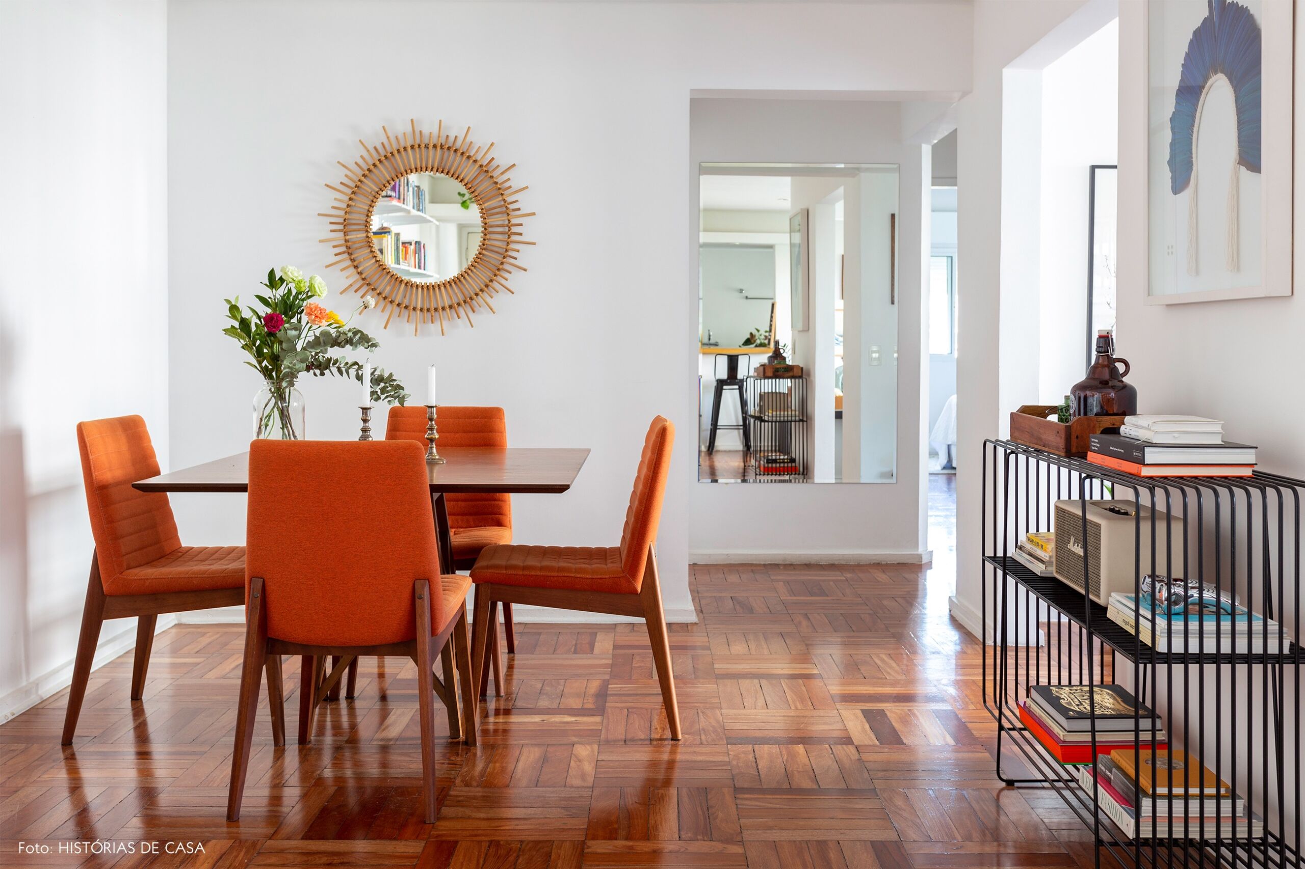 Sala de jantar com cadeiras laranja e piso de tacos