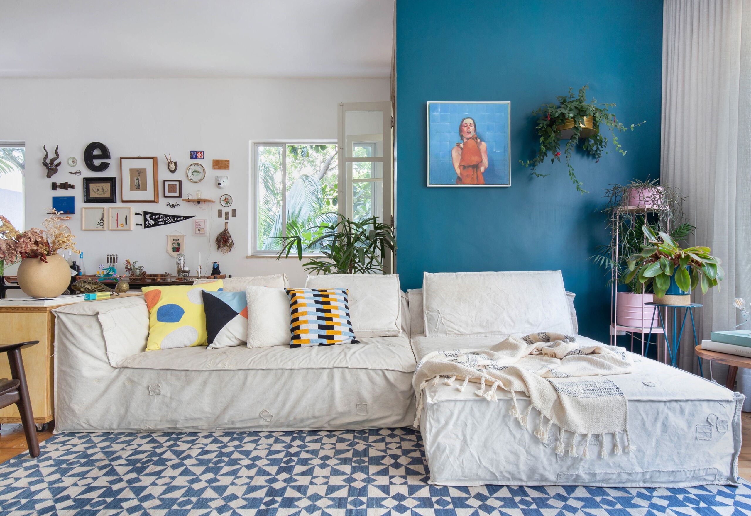 sala com parede azul e almofadas coloridas
