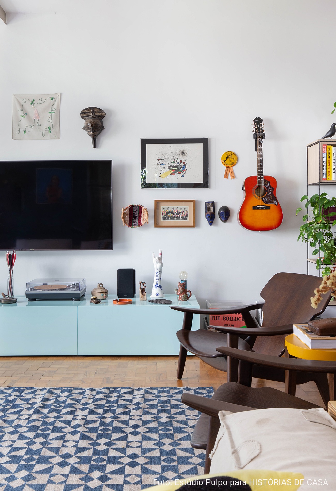 sala de televisão com quadros e violão exposto