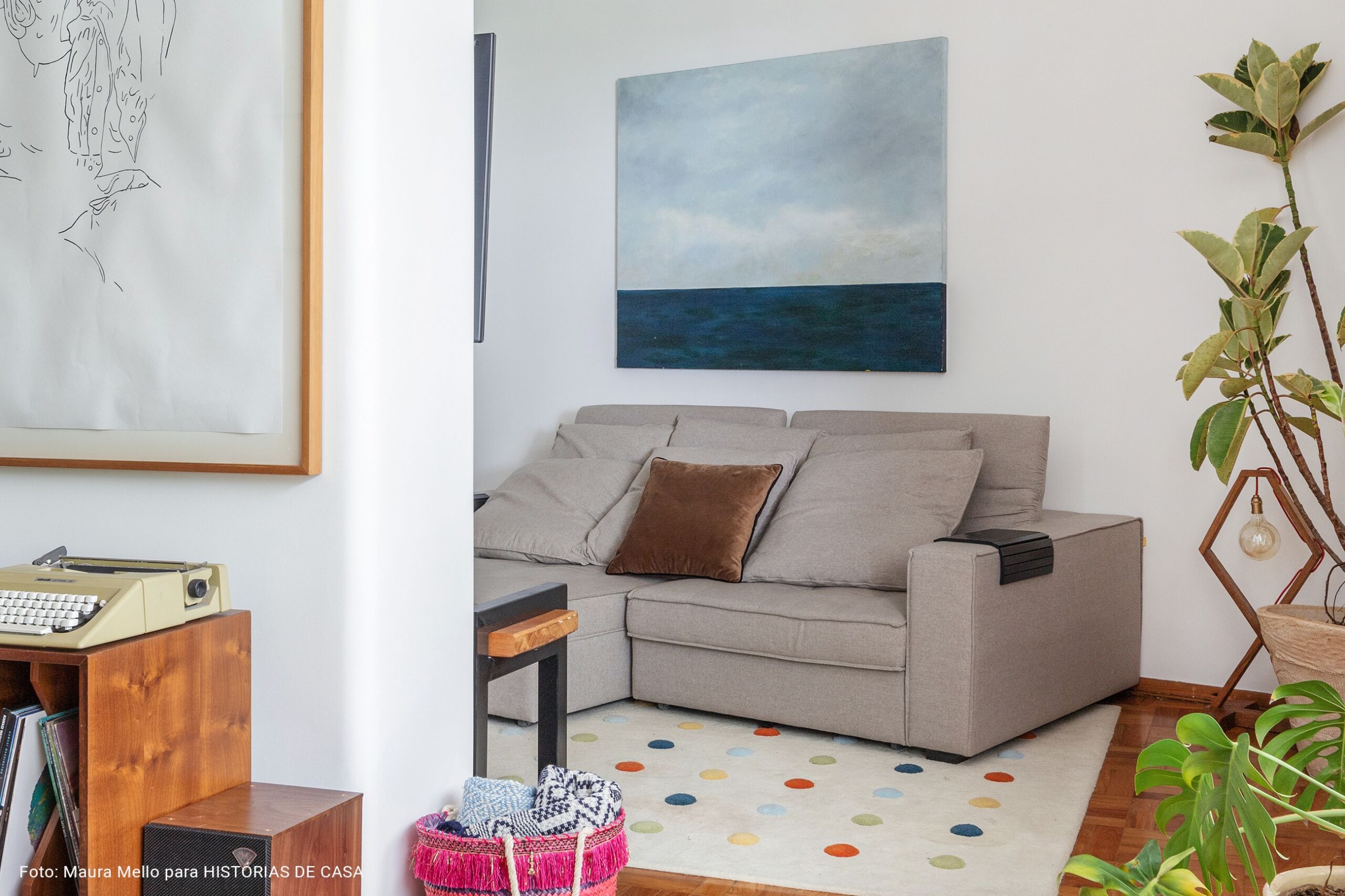 Sala de TV com tapete colorido e sofá cinza