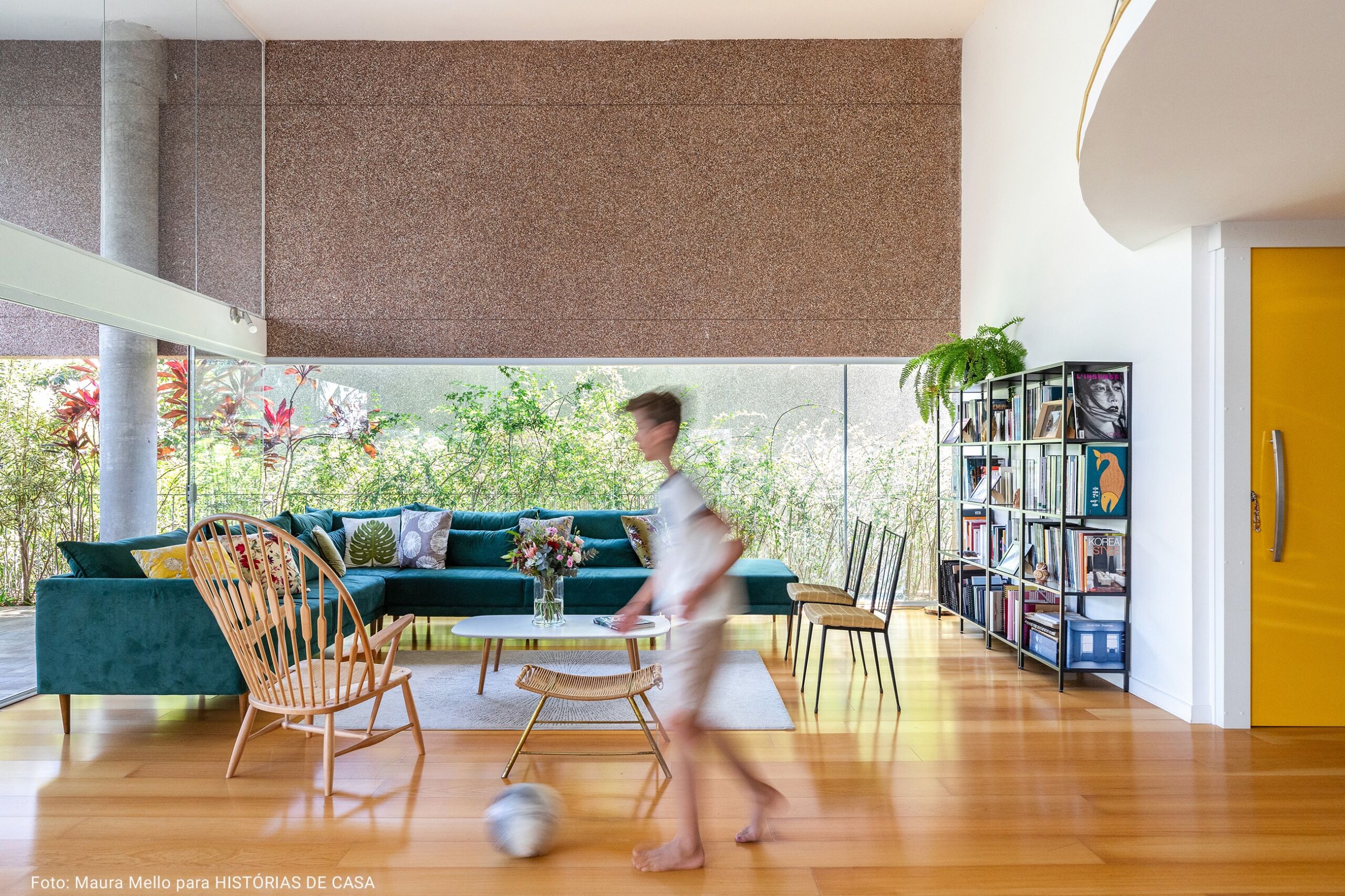 sala com sofá turquesa e estante de livros em metal