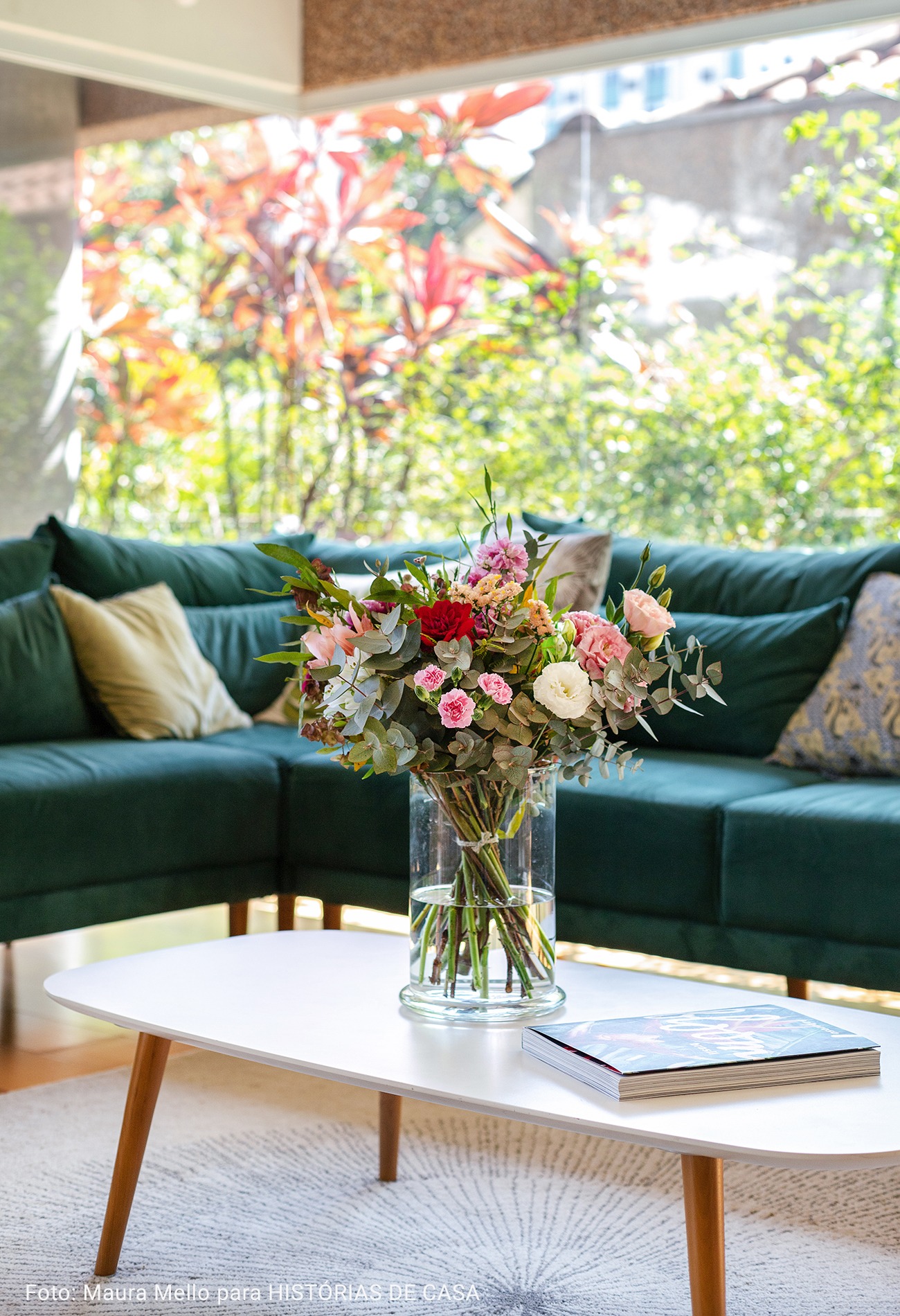 mesa de centro branca com flores e livro
