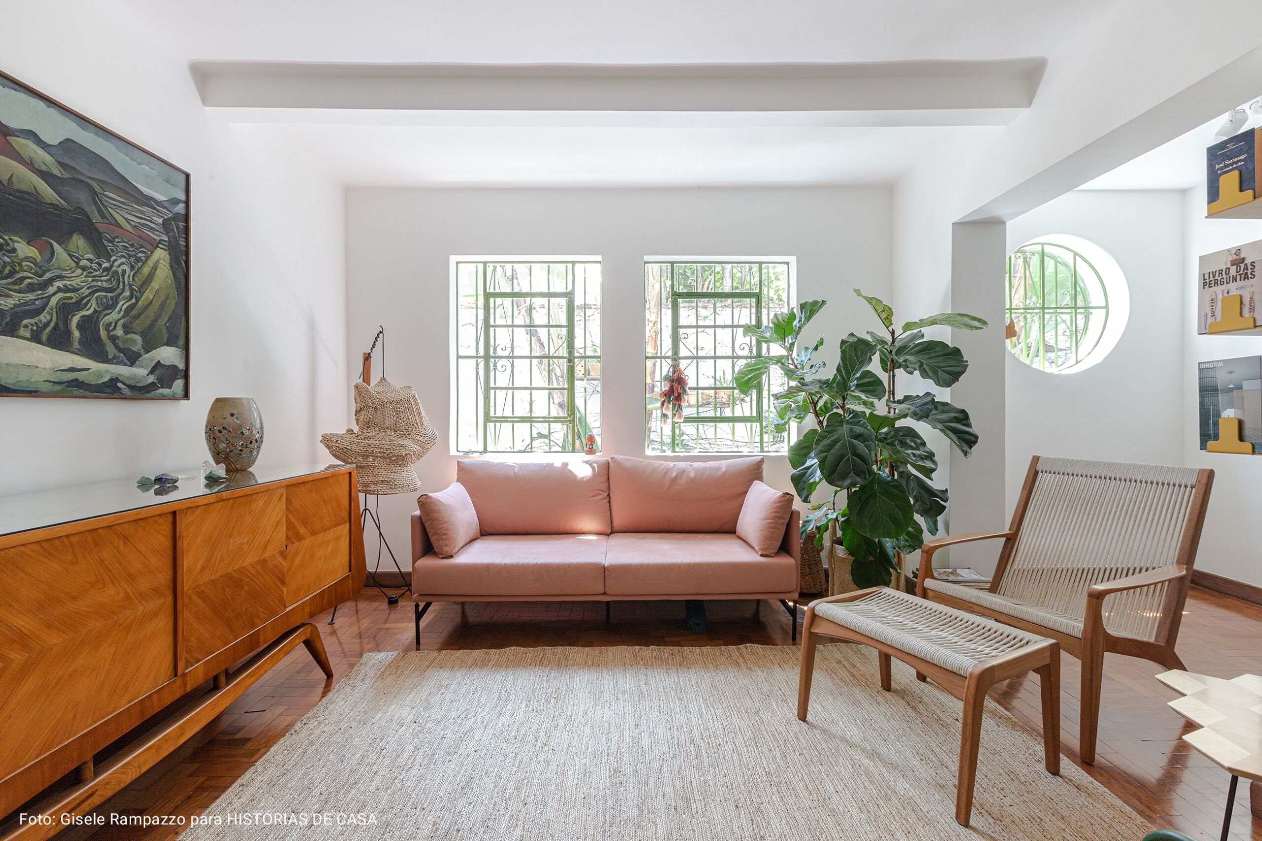 Sala de estar com sofá rosa claro e tapete neutro