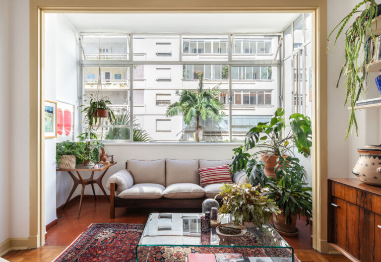 sala com sofá areia e janela ampla